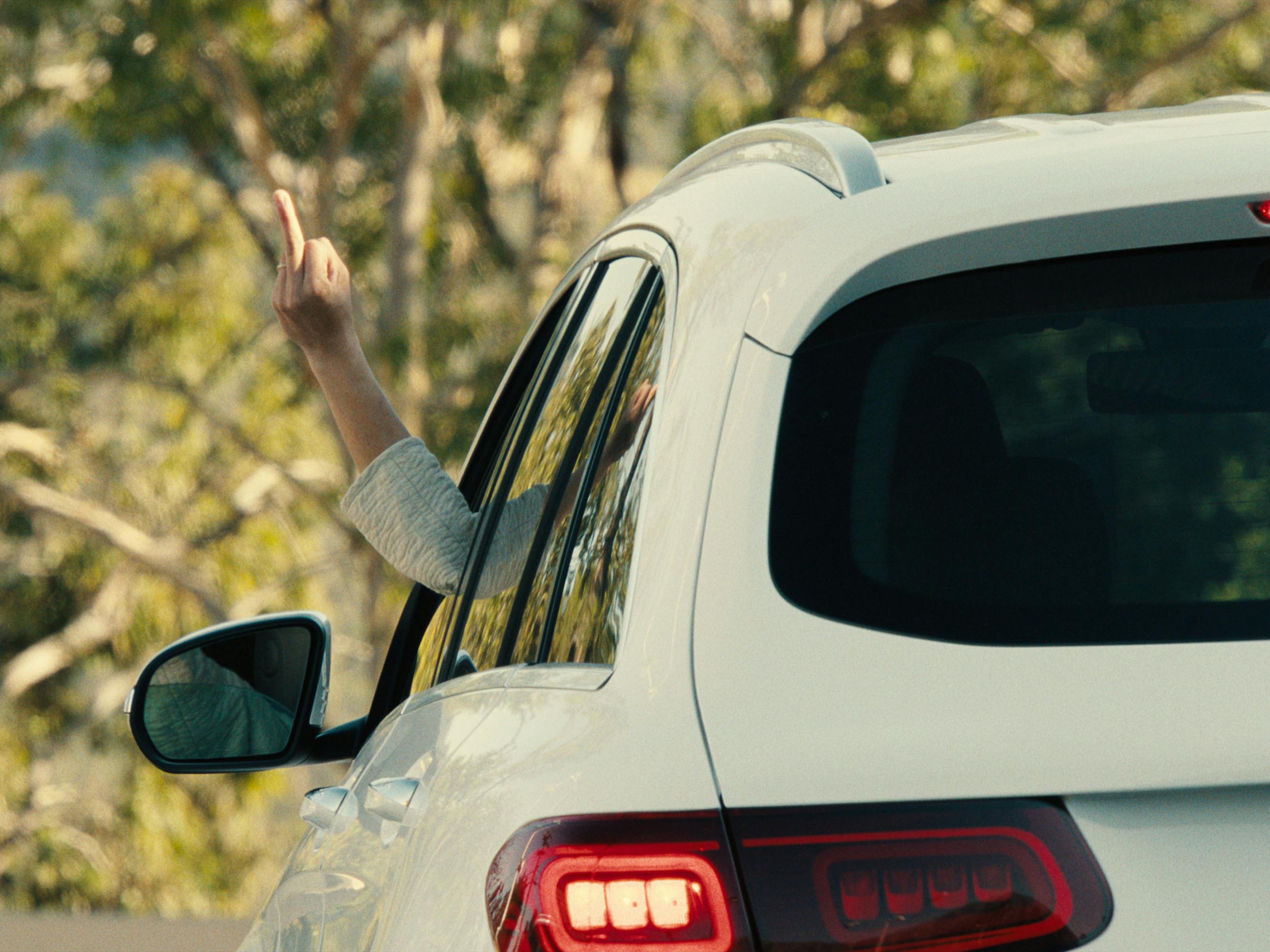 Amy Lau (Amy Wong) gives the finger outside a white car in BEEF.