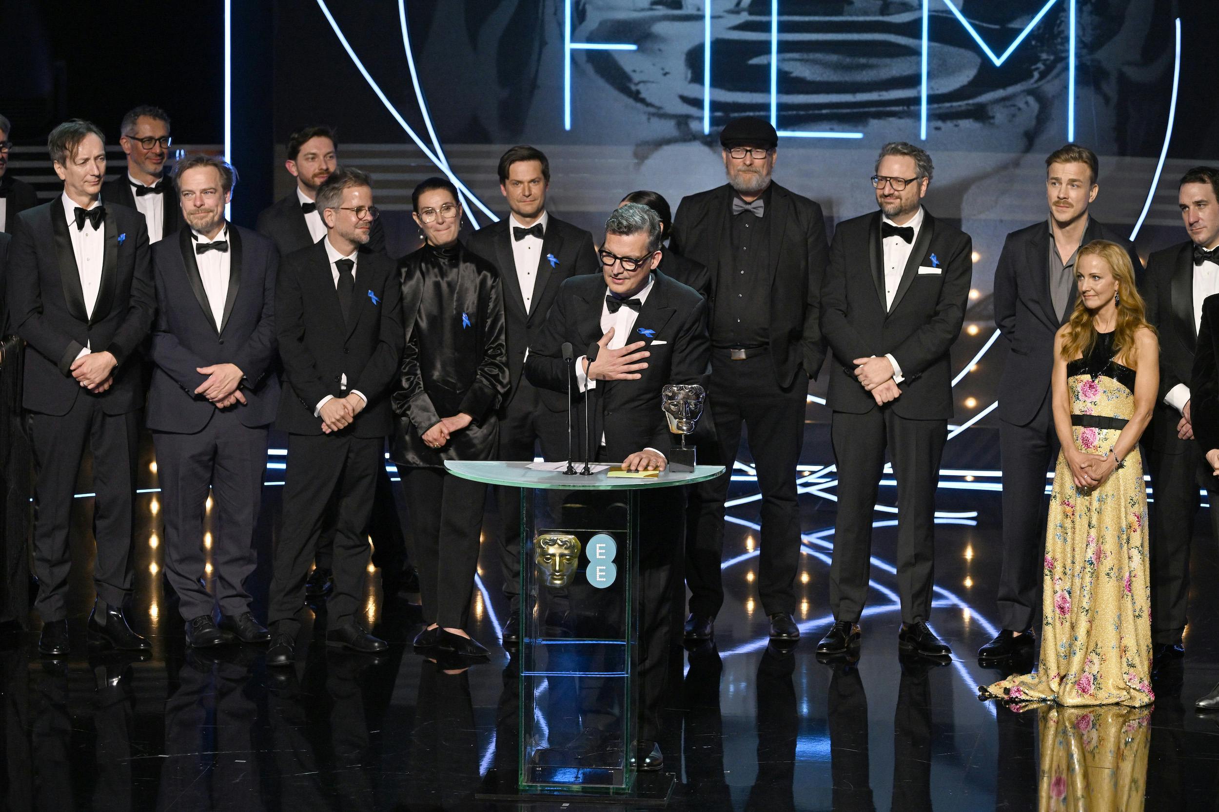 Volker Bertelmann, Frank Petzold, Viktor Prasil, Christian M Goldbeck, Lisy Christl, Malte Grunert, Ian Stokell, Sven Budelmann, Albrecht Schuch, Lesley Paterson, and James Friend accept their BAFTA onstage.