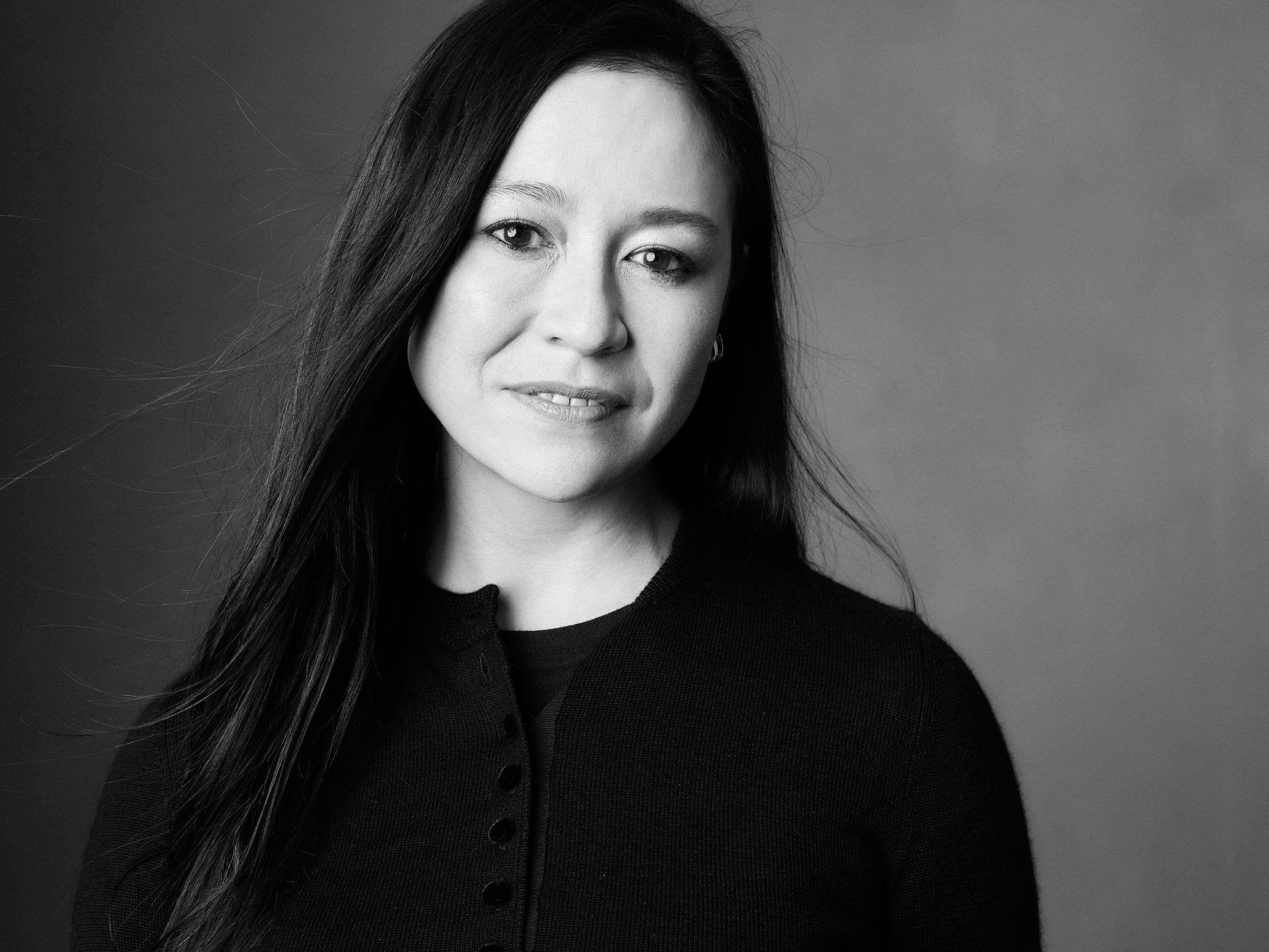 Elizabeth Chai Vasarhelyi wears a black top and smiles at the camera.