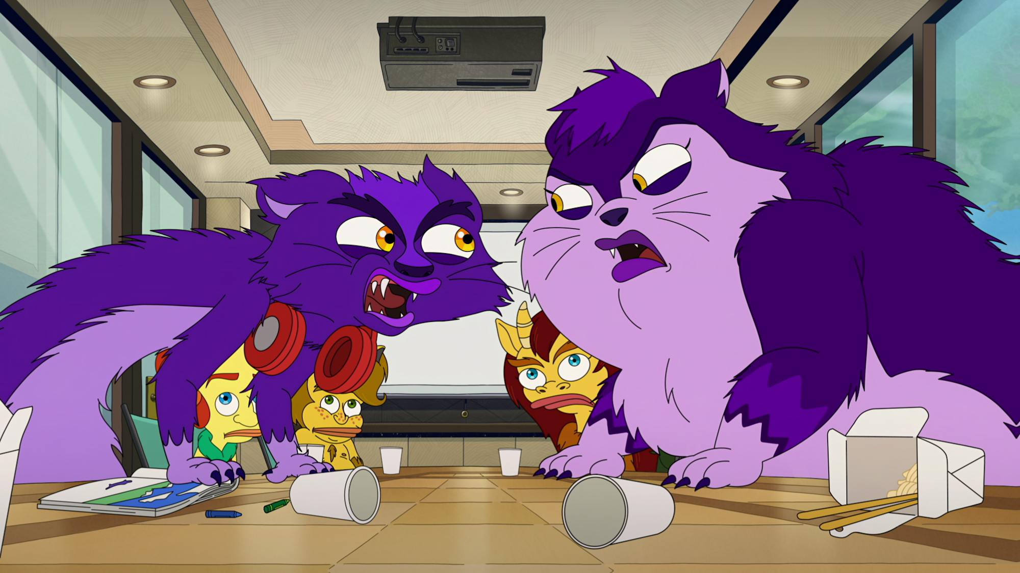 A few creatures sit around an office table eating takeout food and spilling cups as other creatures look on afraid.