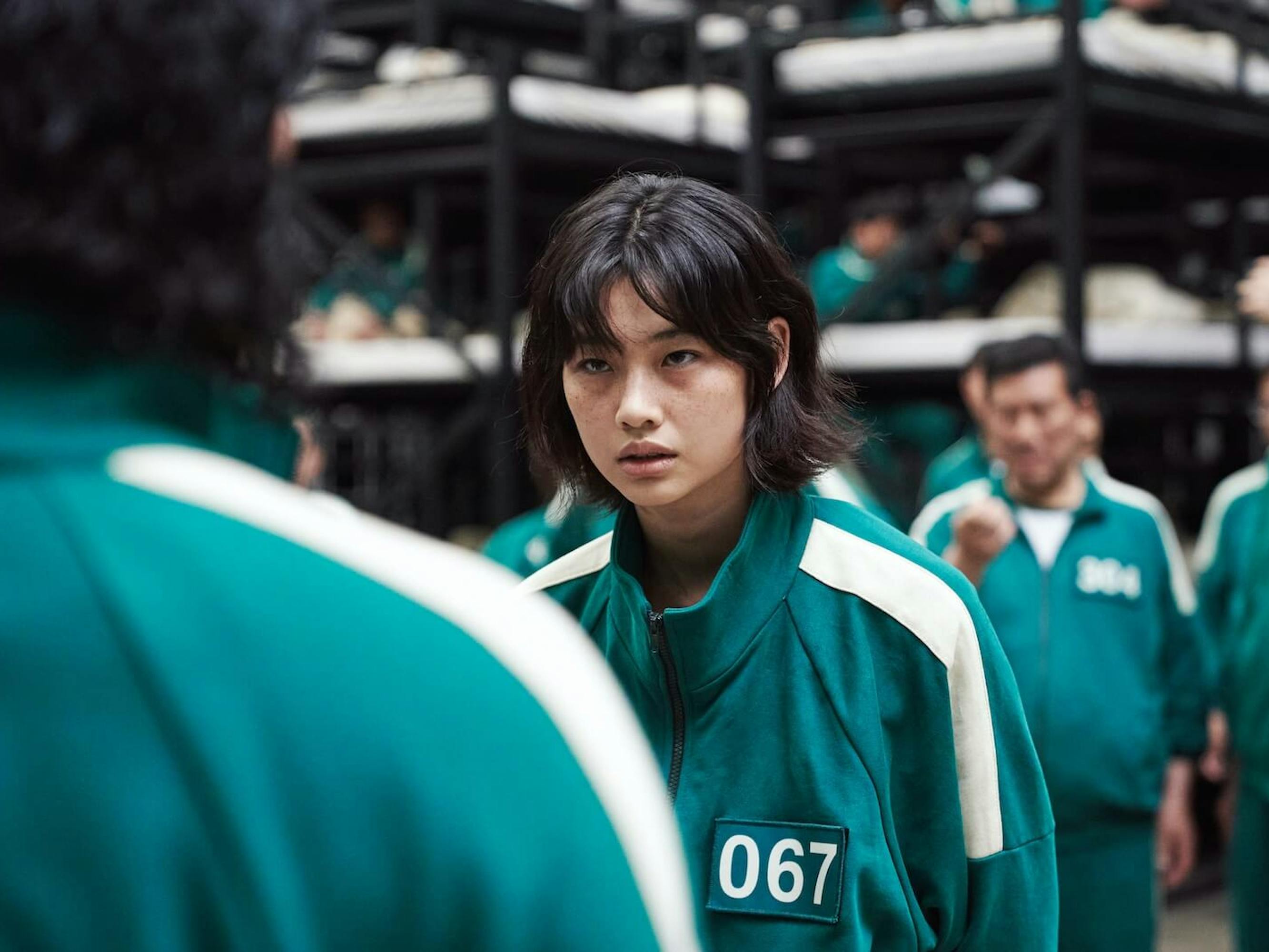 Sae-byeok (Jung Ho-yeon) wears a green-and-white tracksuit with a 067 patch.