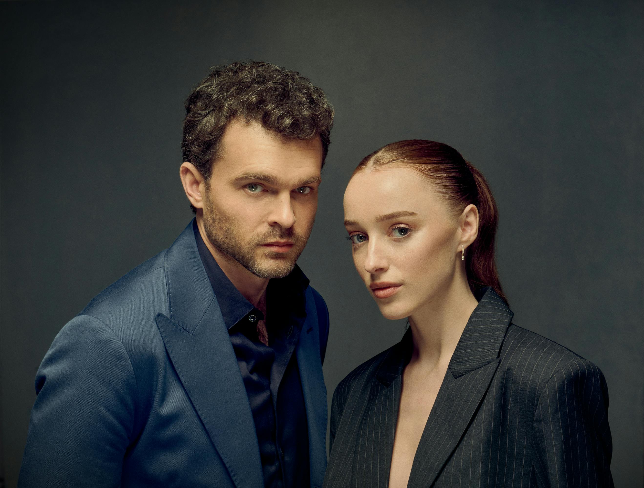 Alden Ehrenreich and Phoebe Dynevor pose in navy and black blazers, respectively, looking snatched and serious. 
