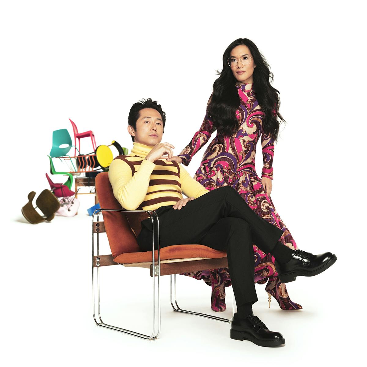 Multiple versions of Ali Wong and Steven Yeun sit and stand around an assortment of chairs. 