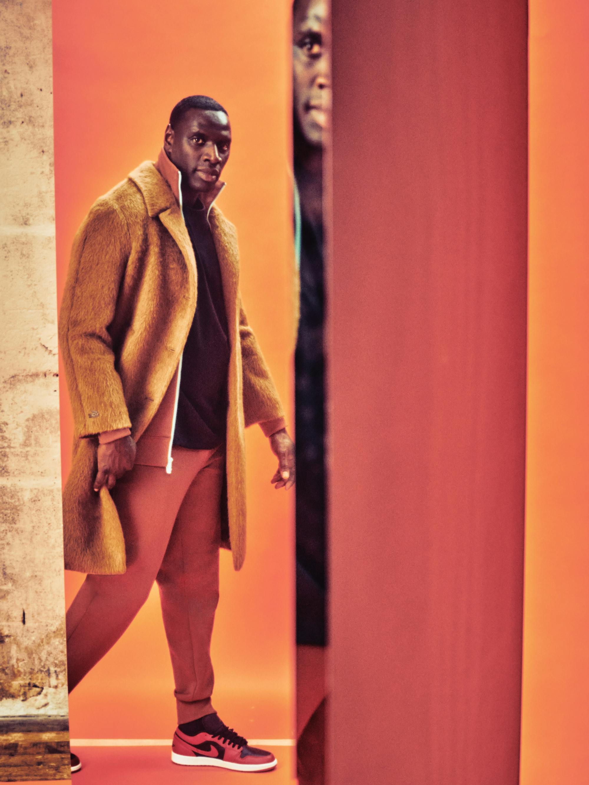 More reflections of Sy, this time in a long orange-brown coat and red Jordan 1s.