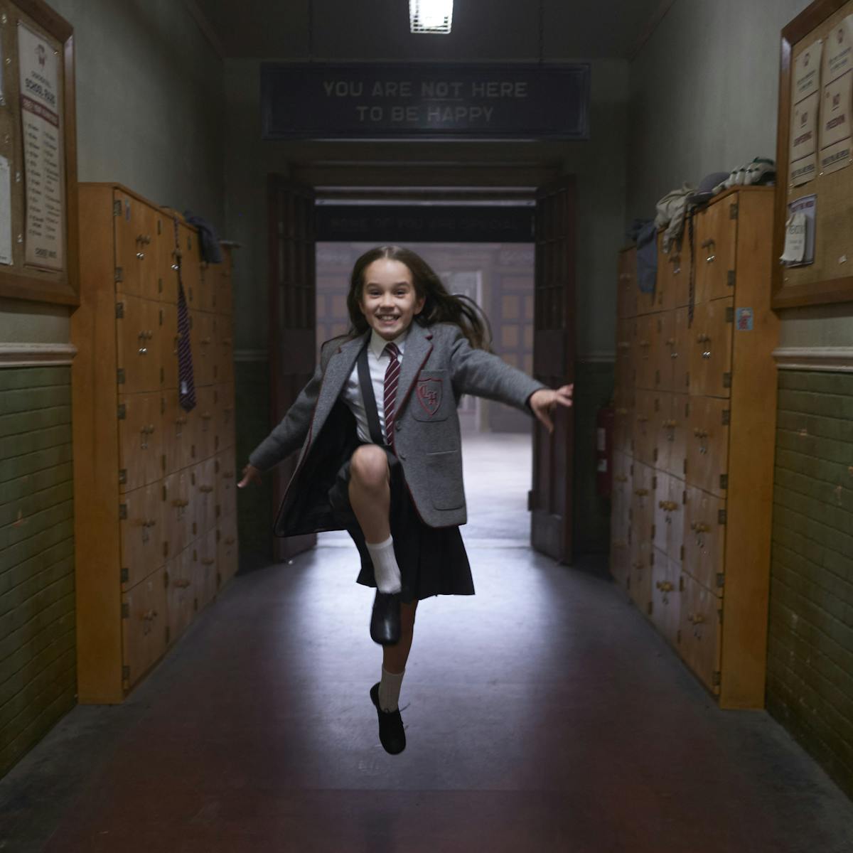 Matilda (Alisha Weir) dances down the hallway in her school uniform. 
