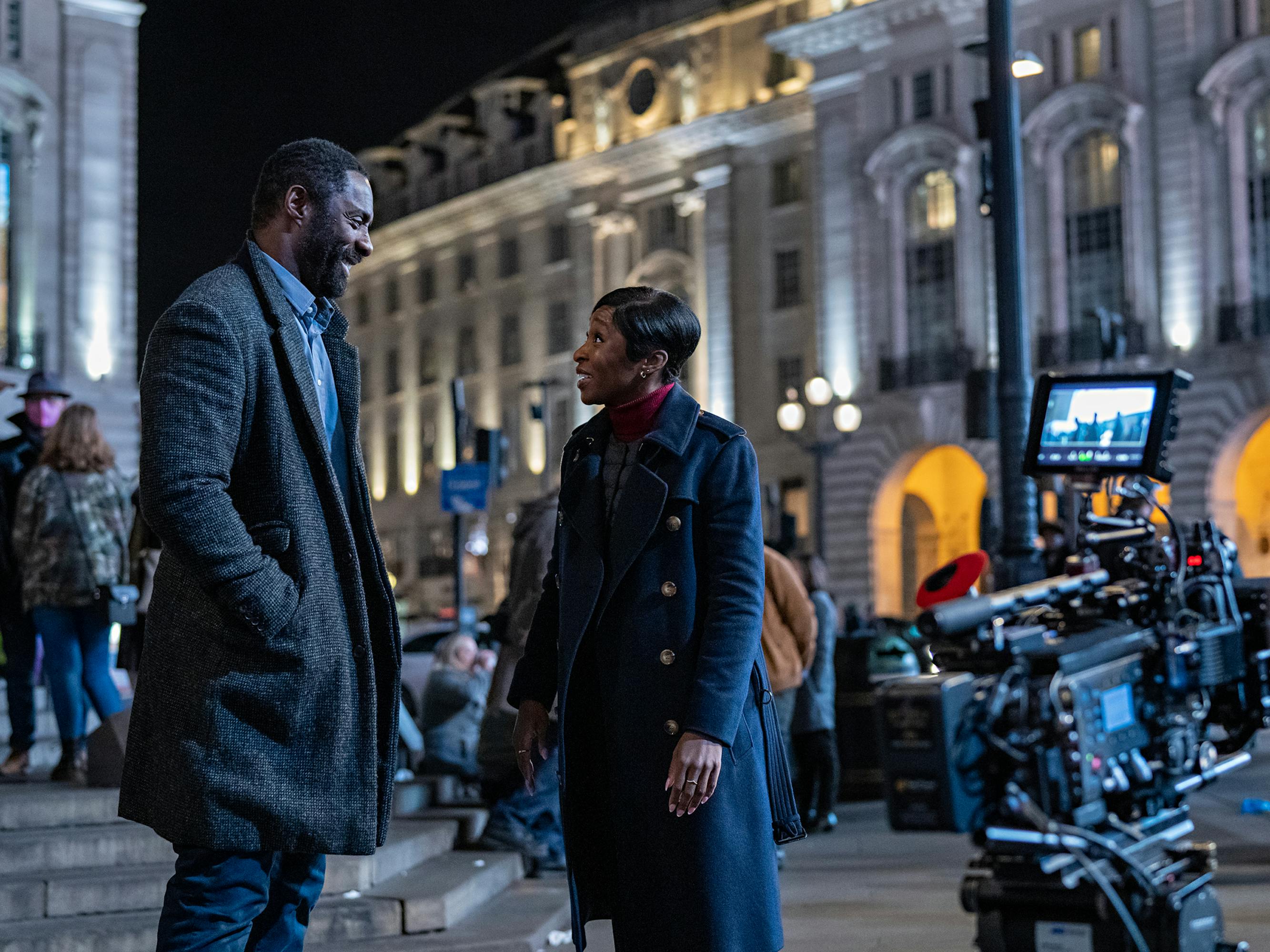 John Luther (Idris Elba) and Odette Raine (Cynthia Erivo) stand together behind the scenes. 