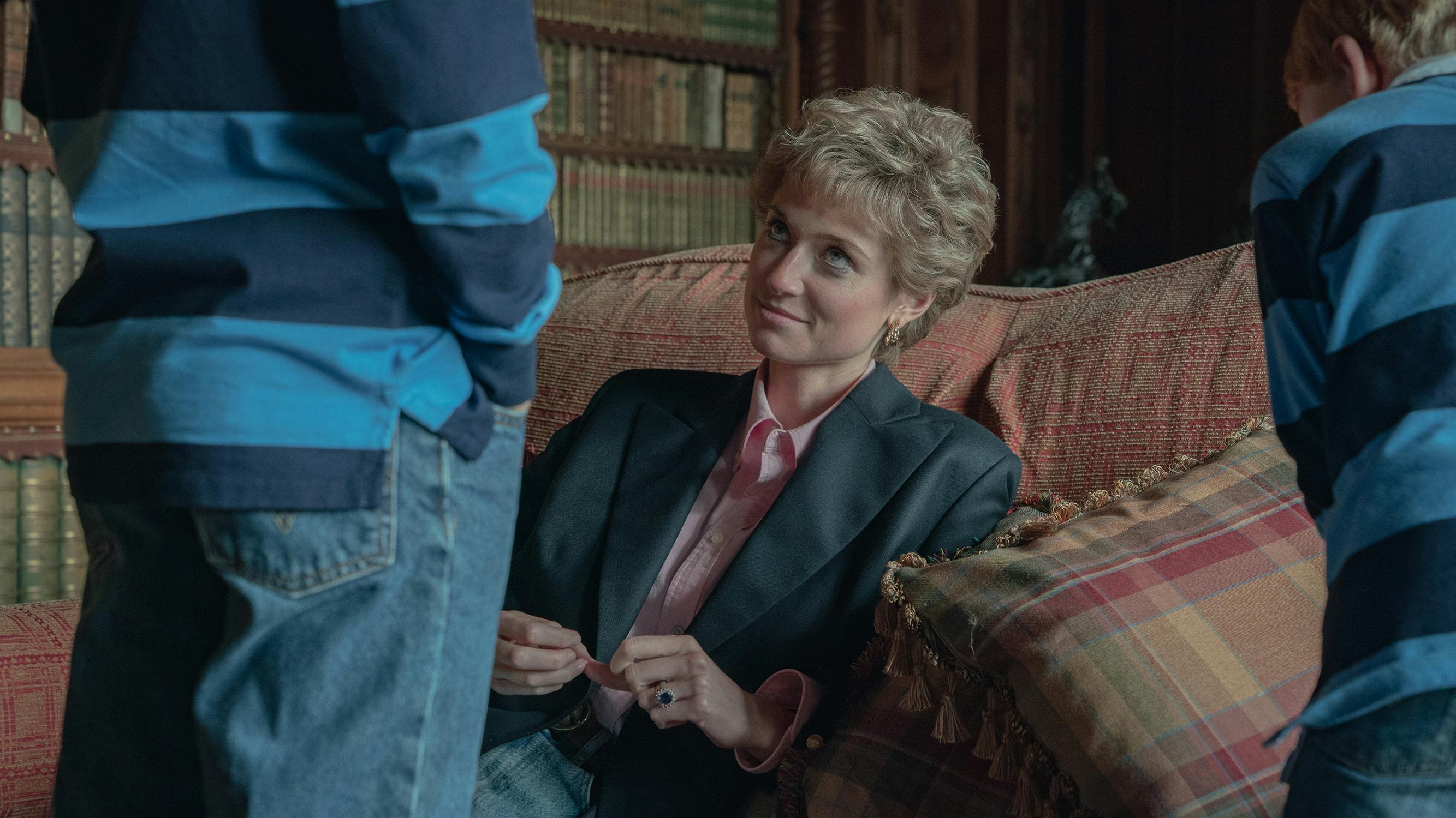 Princess Diana (Elizabeth Debicki) sits on a patterned couch with her boys facing her, their backs to the camera.