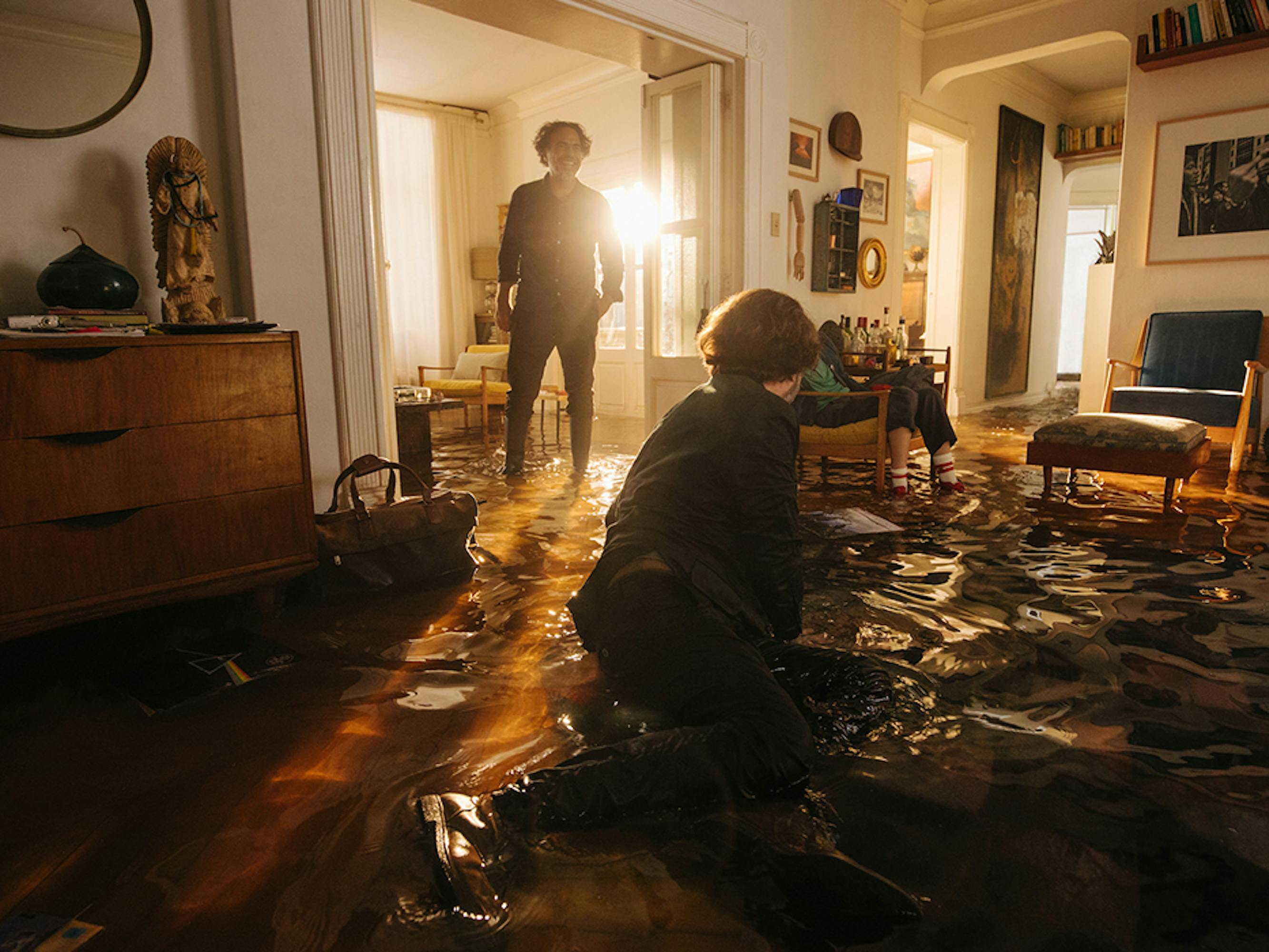 Daniel Giménez Cacho and Alejandro González Iñárritu talk to each other across a dramatic set: water runs through a living room.