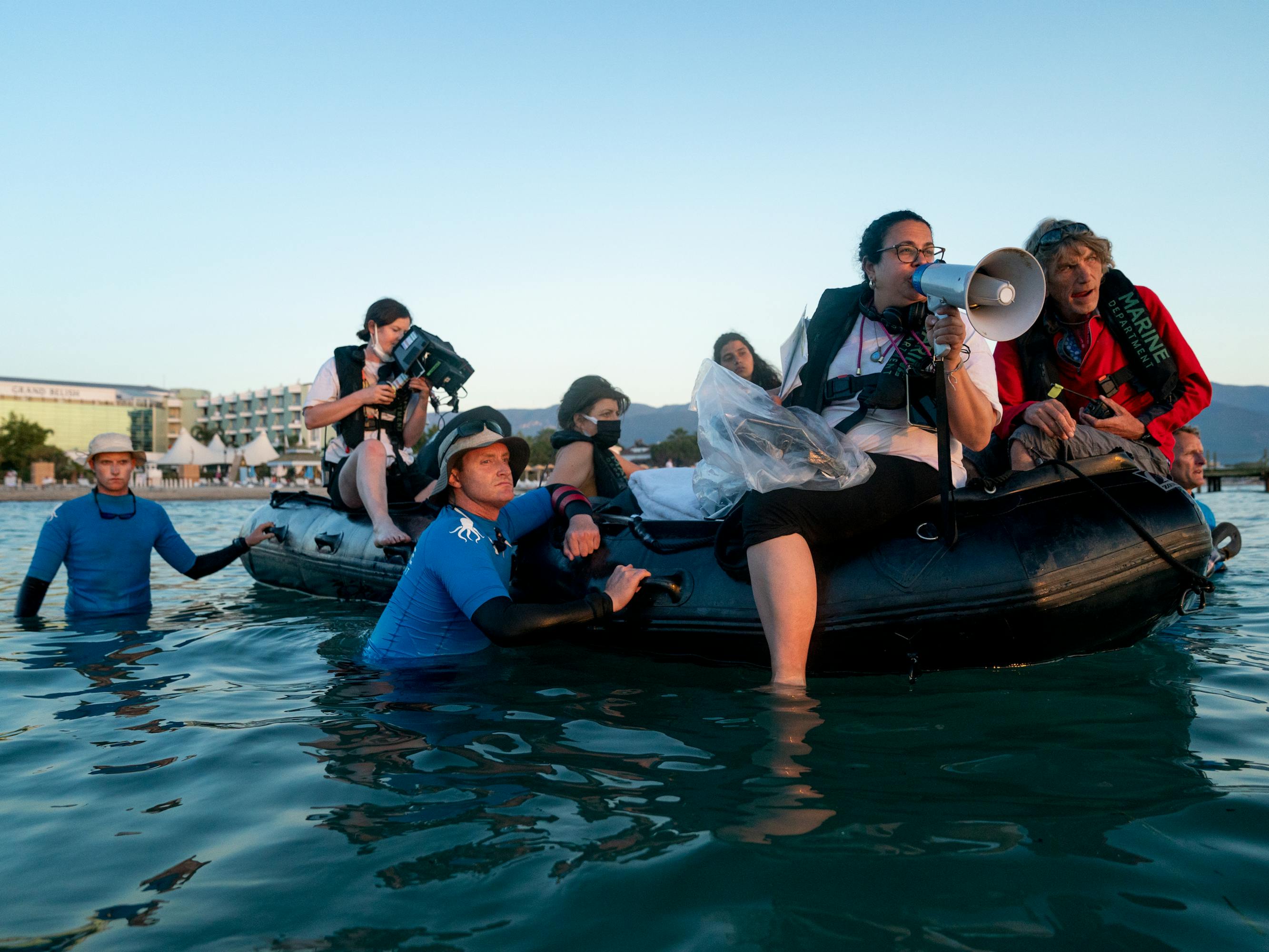 Sally El Hosaini and The Swimmers crew members float on a black inflatable.