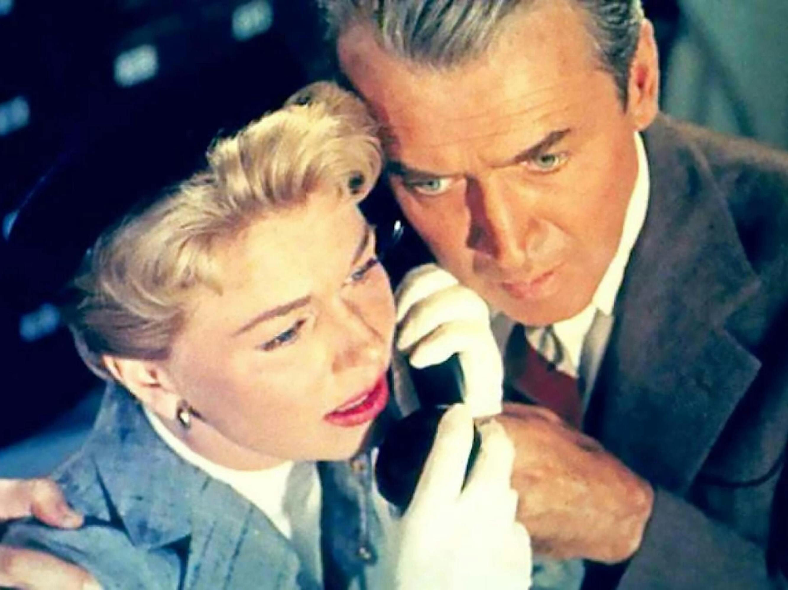 Josephine Conway McKenna (Doris Day) and Dr. Benjamin McKenna (James Stewart) in The Man Who Knew Too Much. They clutch a phone between them. Day wears white gloves and a black beret, and Stewart wears a dark suit.