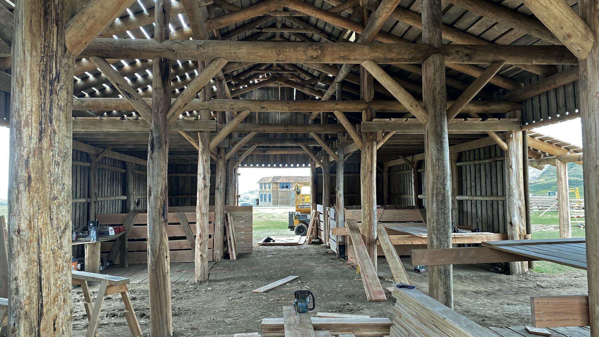 Inside the early stages of building the ranch. The bare bones structure is missing walls and there are tools and boards scattered about the room.