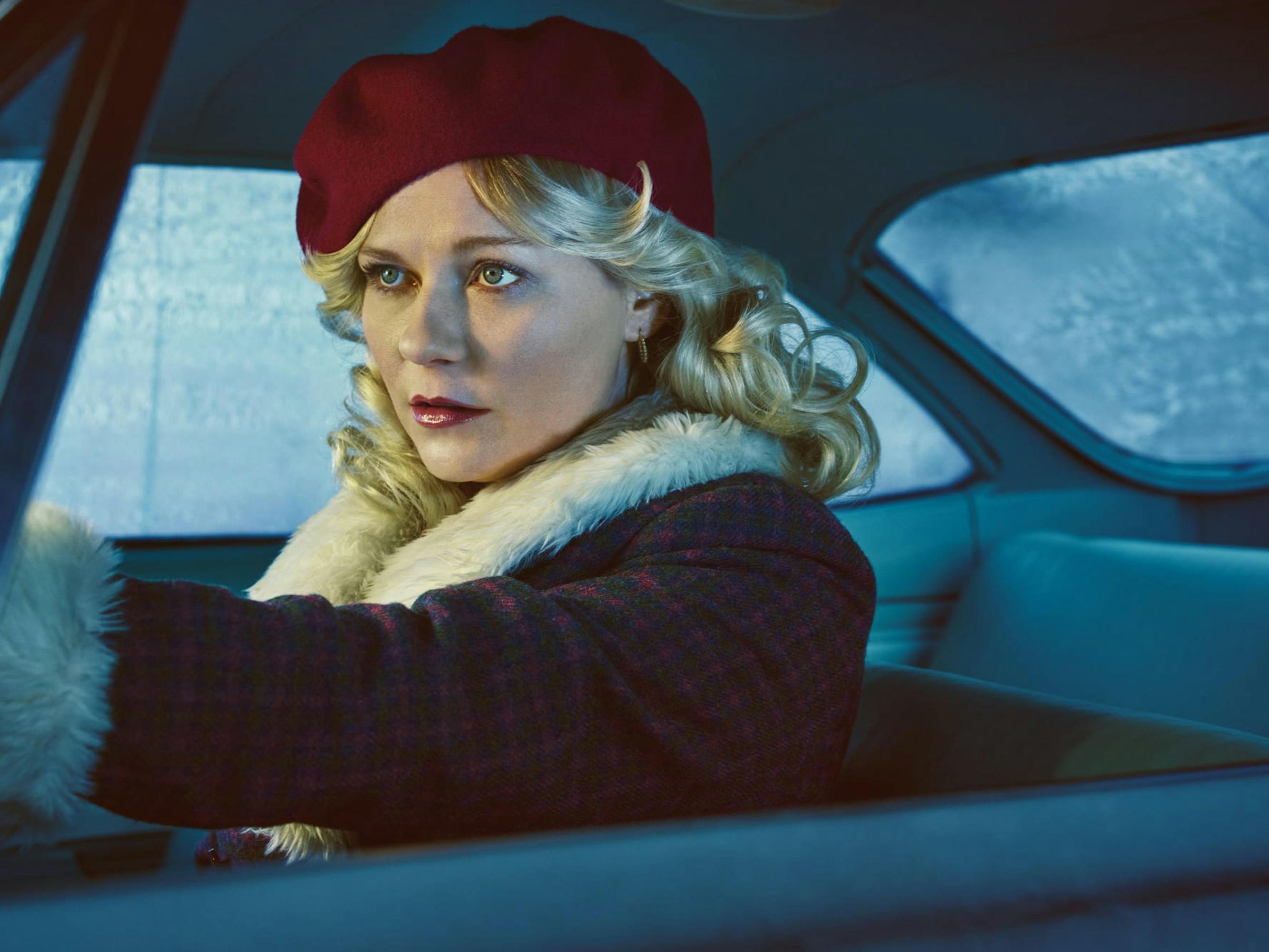 Peggy (Kirsten Dunst) drives a car wearing a fabulous plaid coat trimmed with white fur and a red beret.