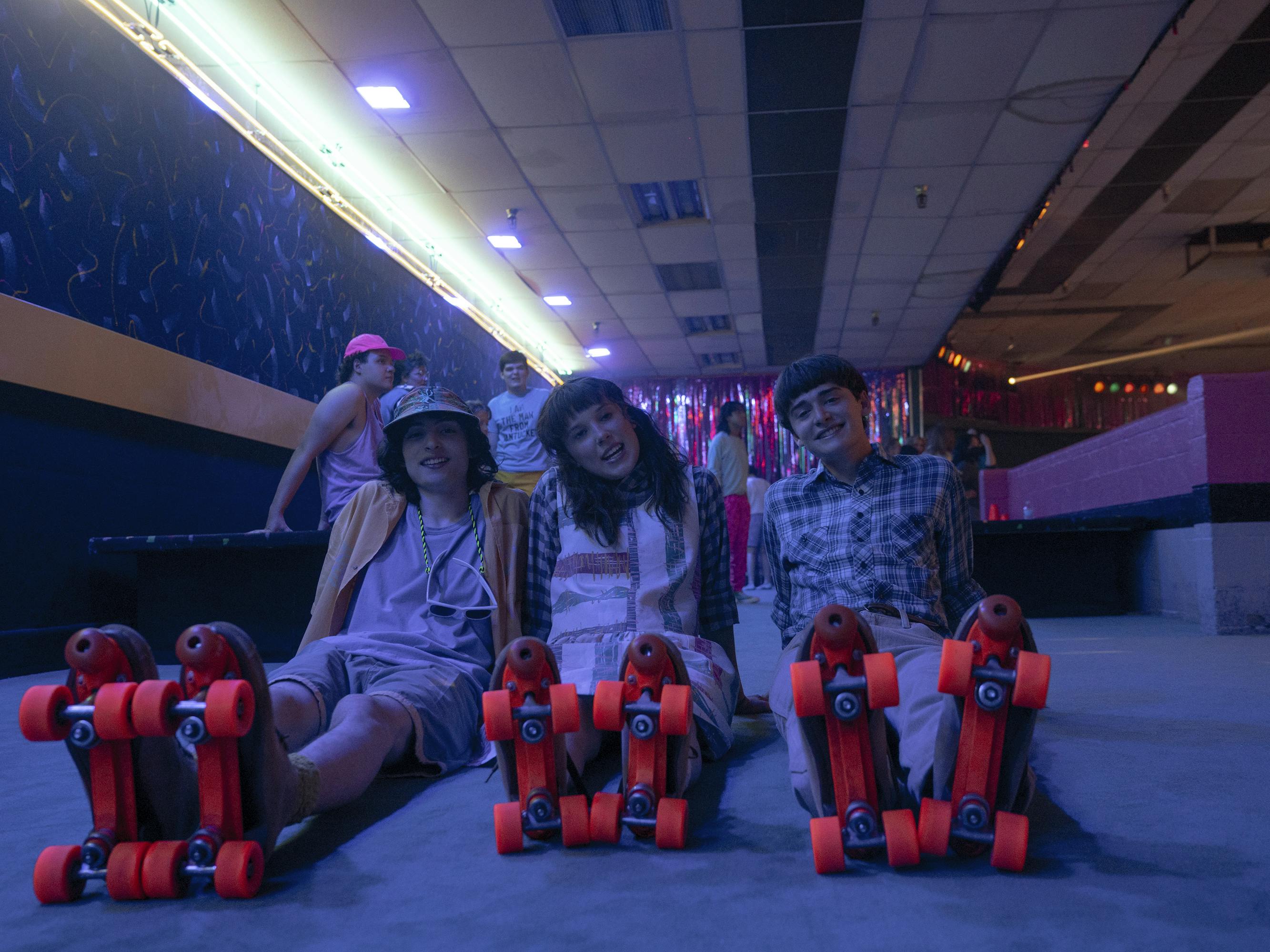 Mike Wheeler (Finn Wolfhard), Eleven (Millie Bobby Brown), and Will Byers (Noah Schnapp) show their roller skate clad feet.