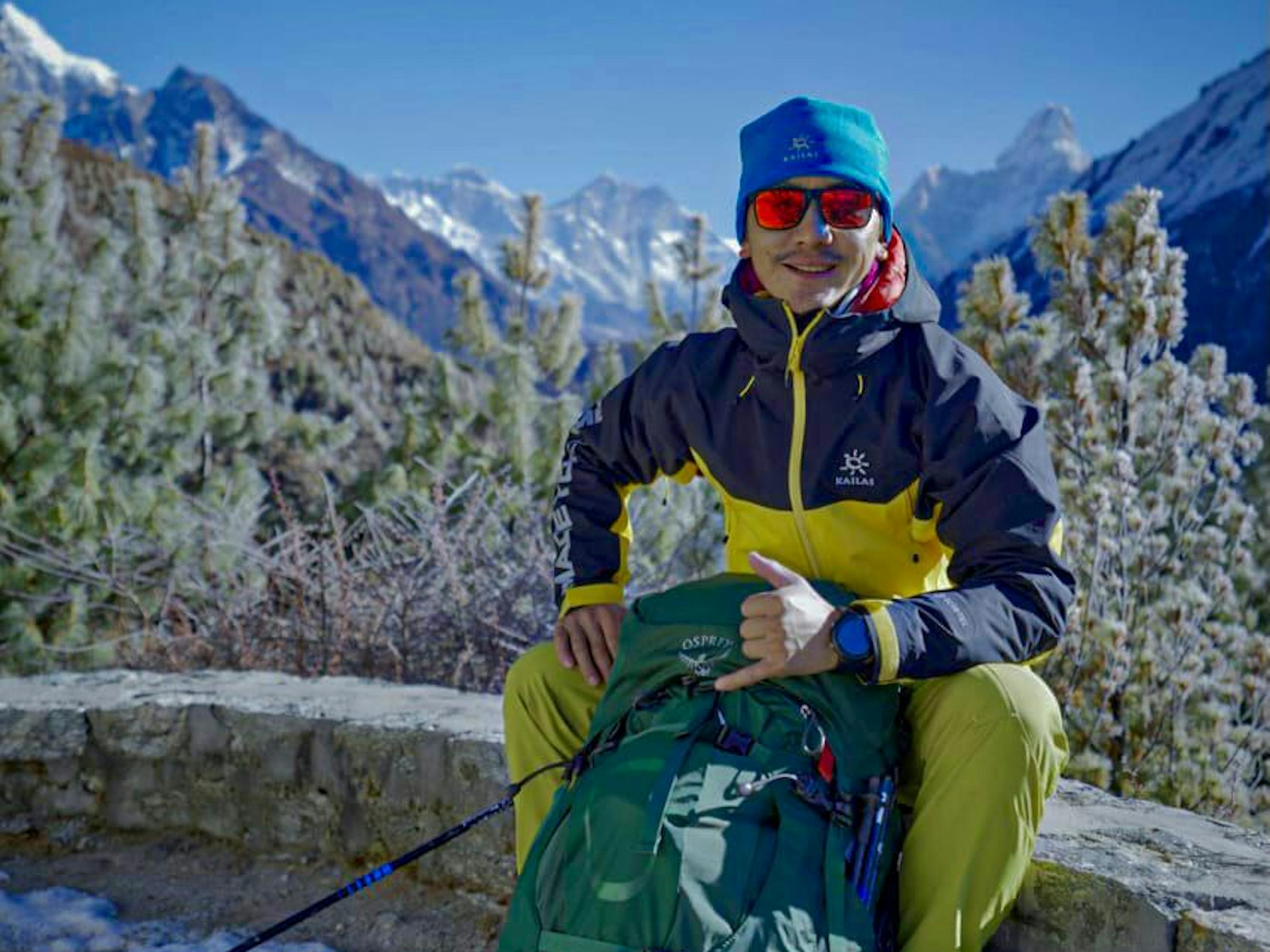 Lakpa Dendi Sherpa holds a giant green bag between his knees.