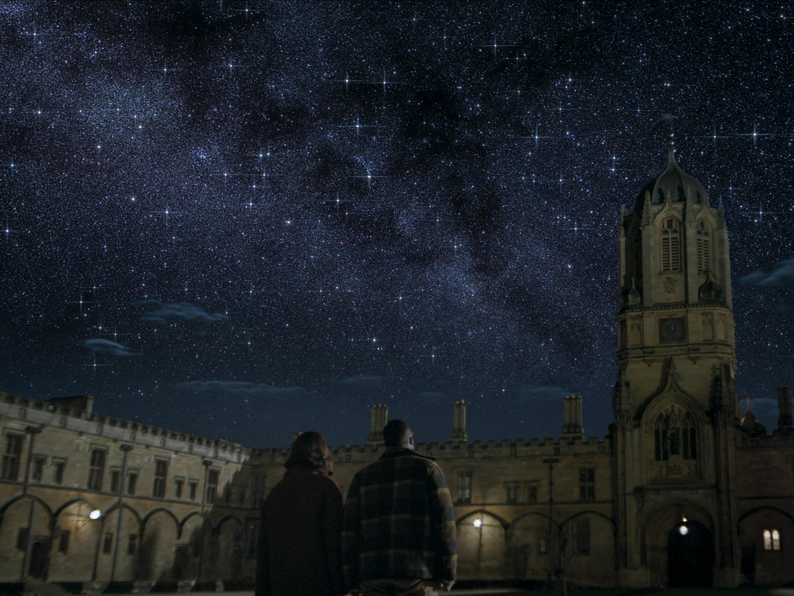 Auggie Salazar (Eiza González) and Saul Durand (Jovan Adepo) look up at a dark, starry sky.
