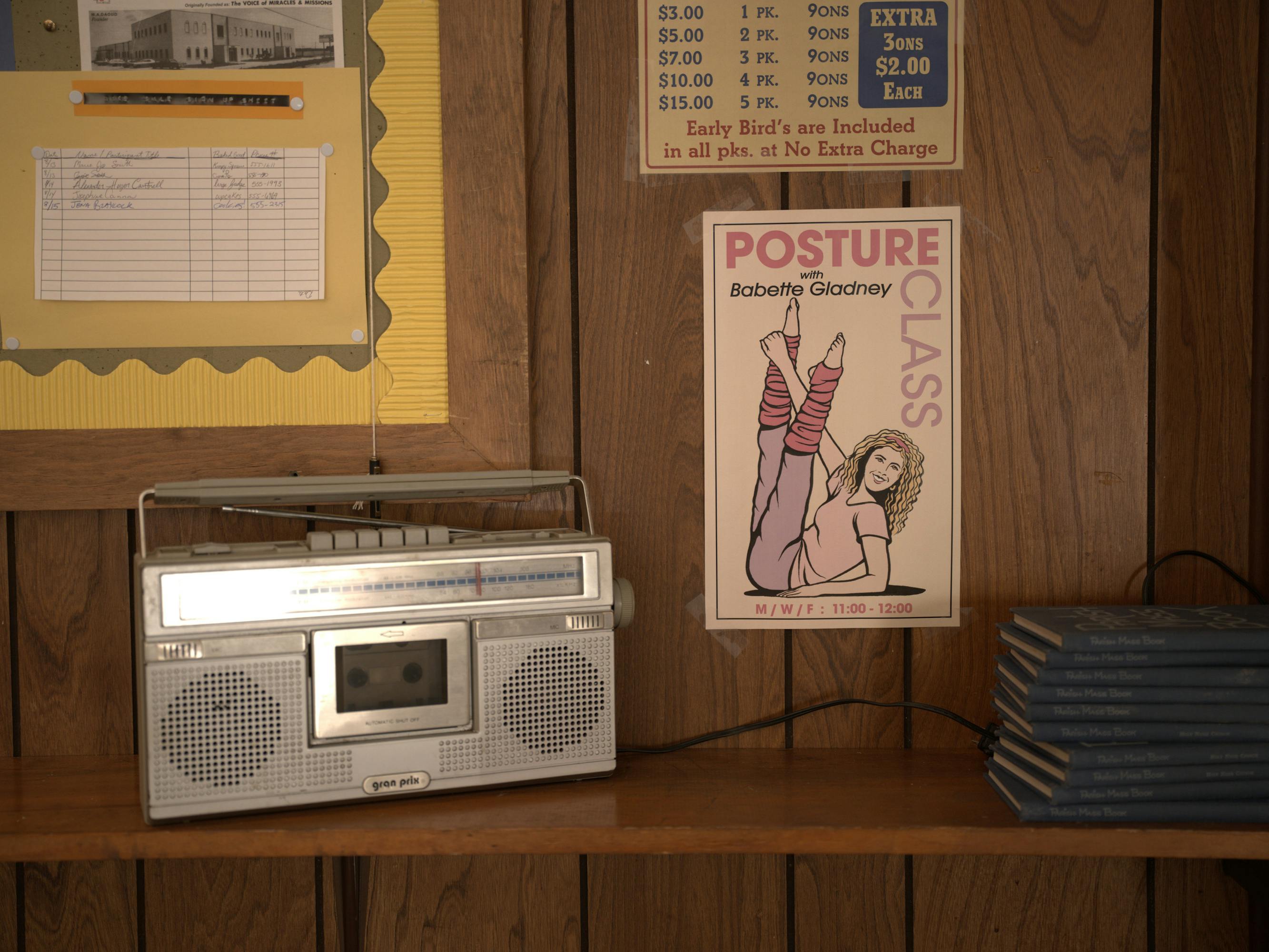 A stereo in an aerobics classroom with some posters and flyers on the wall.