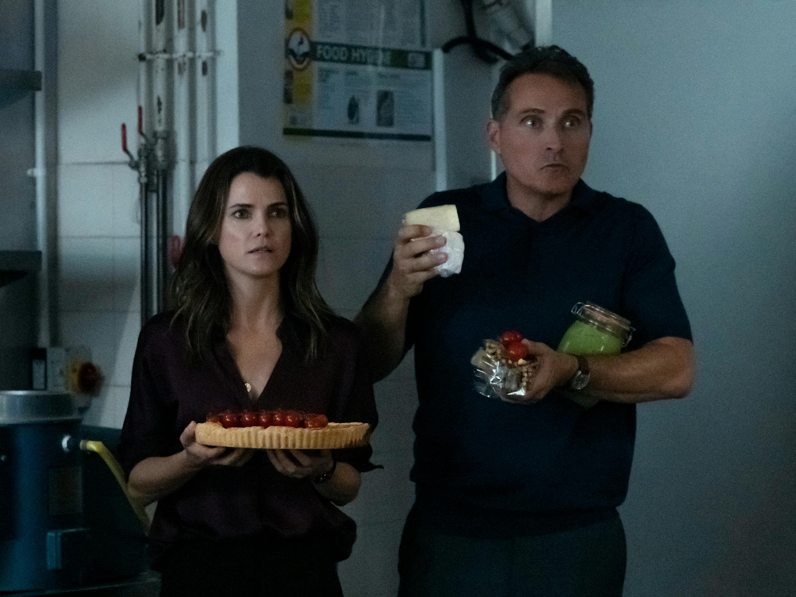 Kate Wyler (Keri Russell) and Hal Wyler (Rufus Sewell) get caught red-handed with some stolen snacks in their arms.