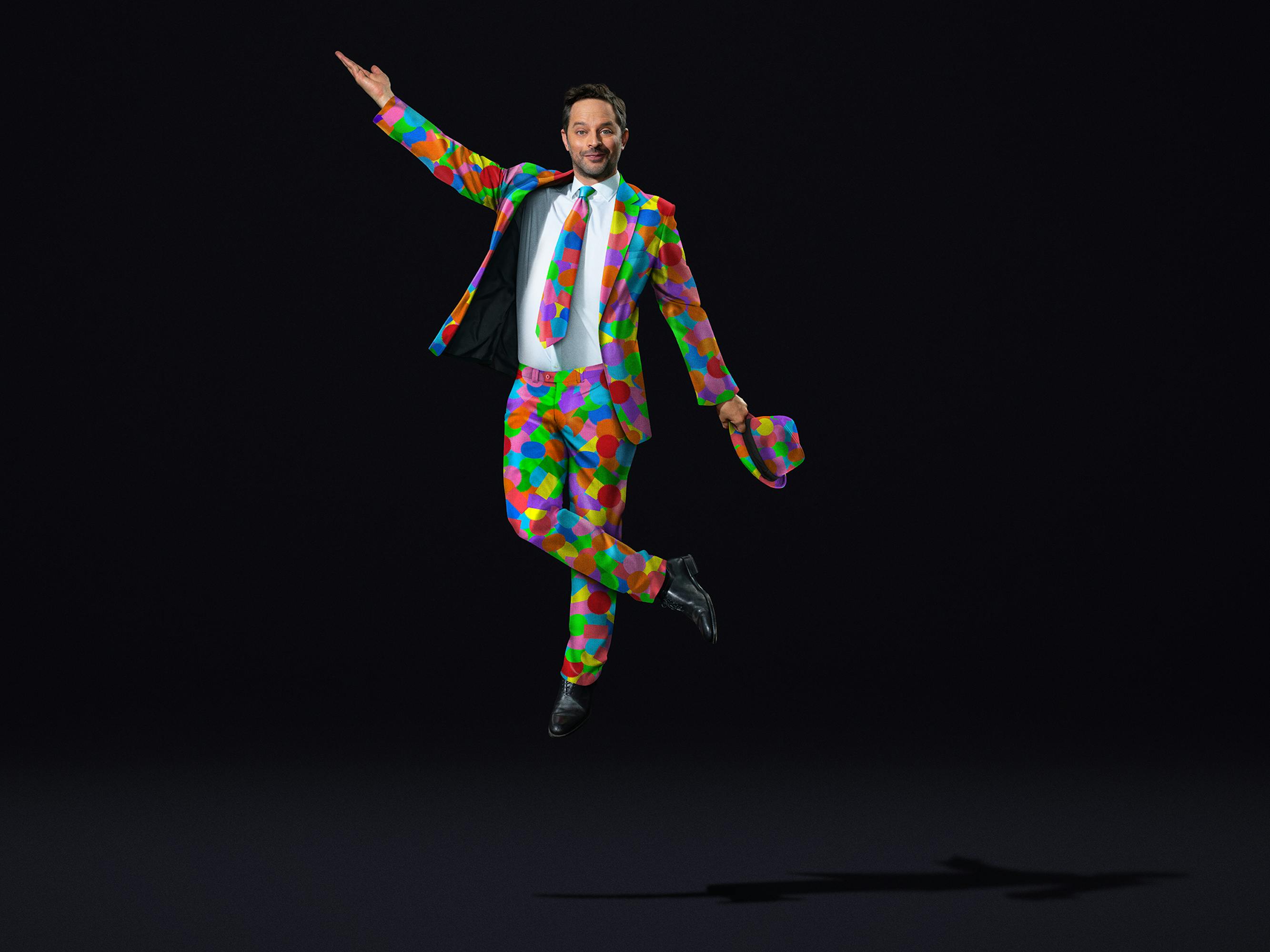 Nick Kroll wears a sticker suit and strikes a pose.