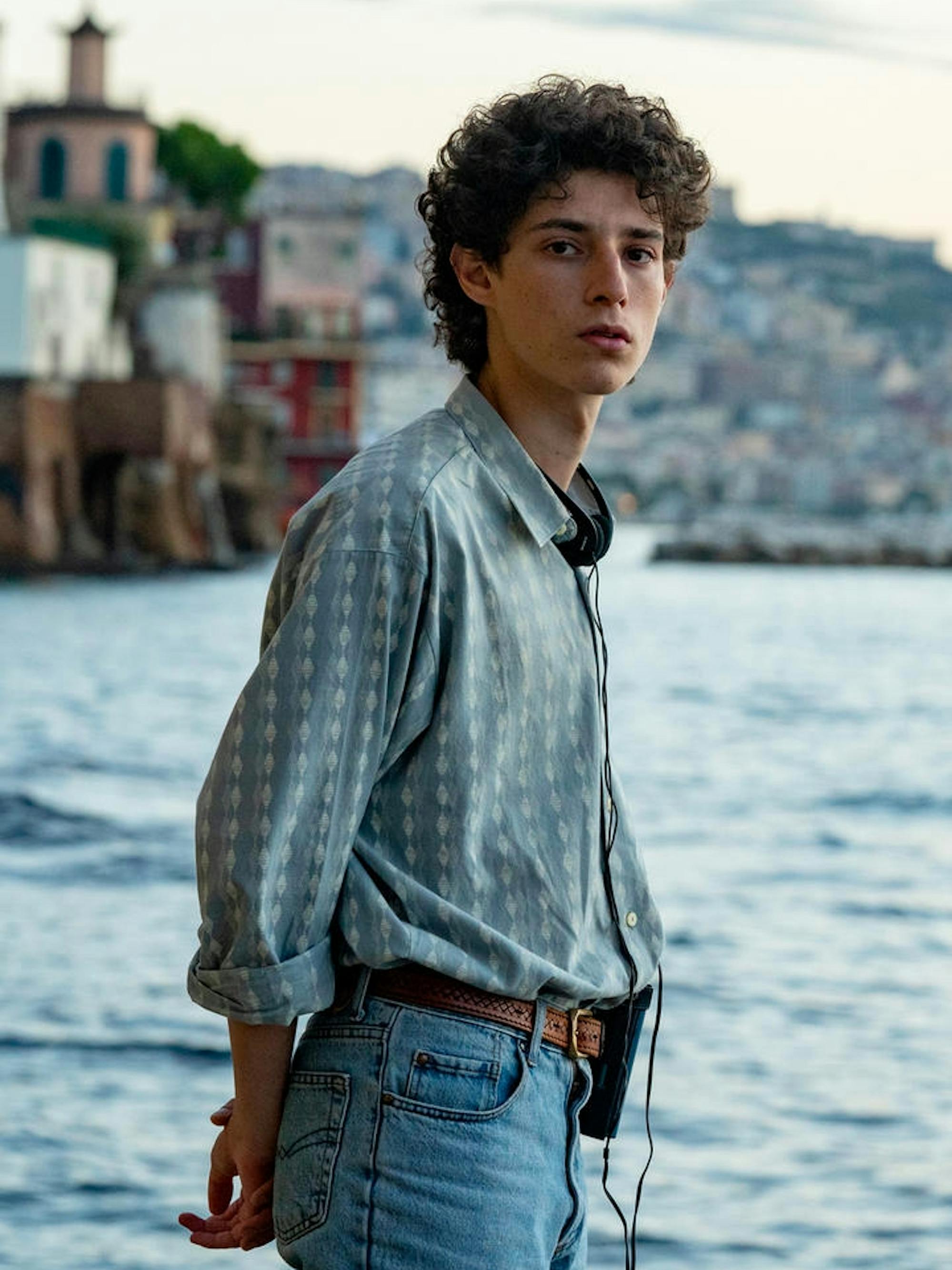 Filippo Scotti stands by the water. In the background are houses on the bank.