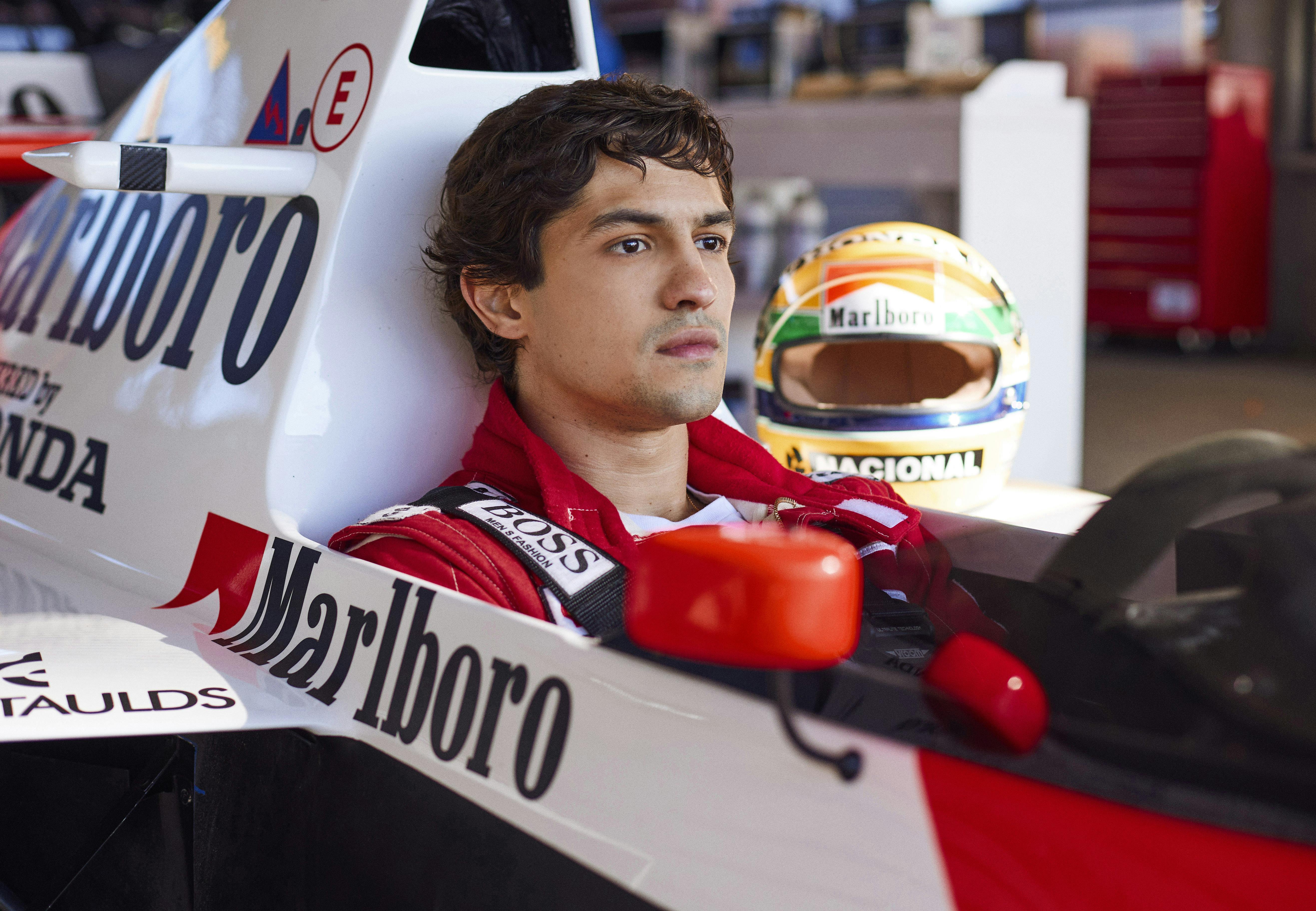 Ayrton Senna (Gabriel Leone) sits in his racecar.