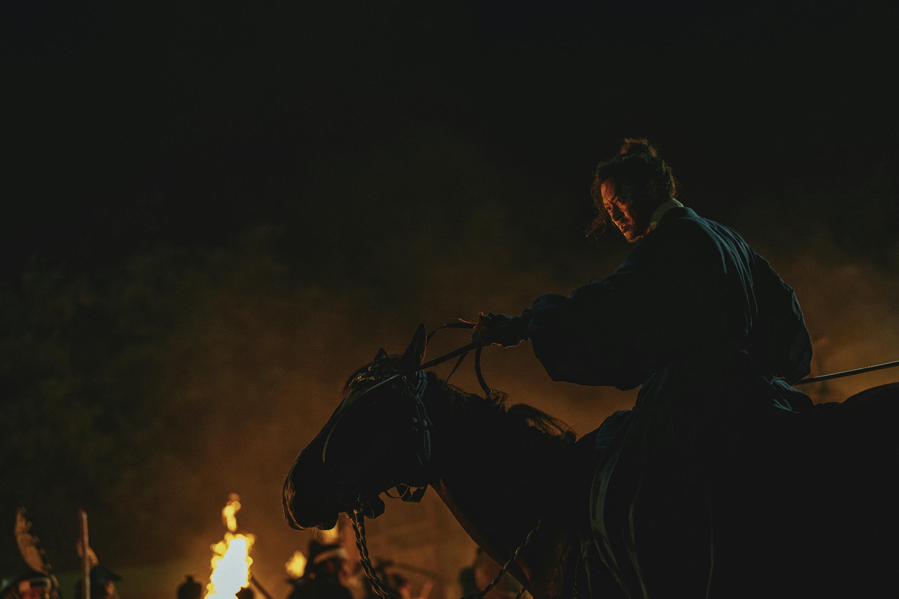 Gang Dong-won rides a horse in the dark.