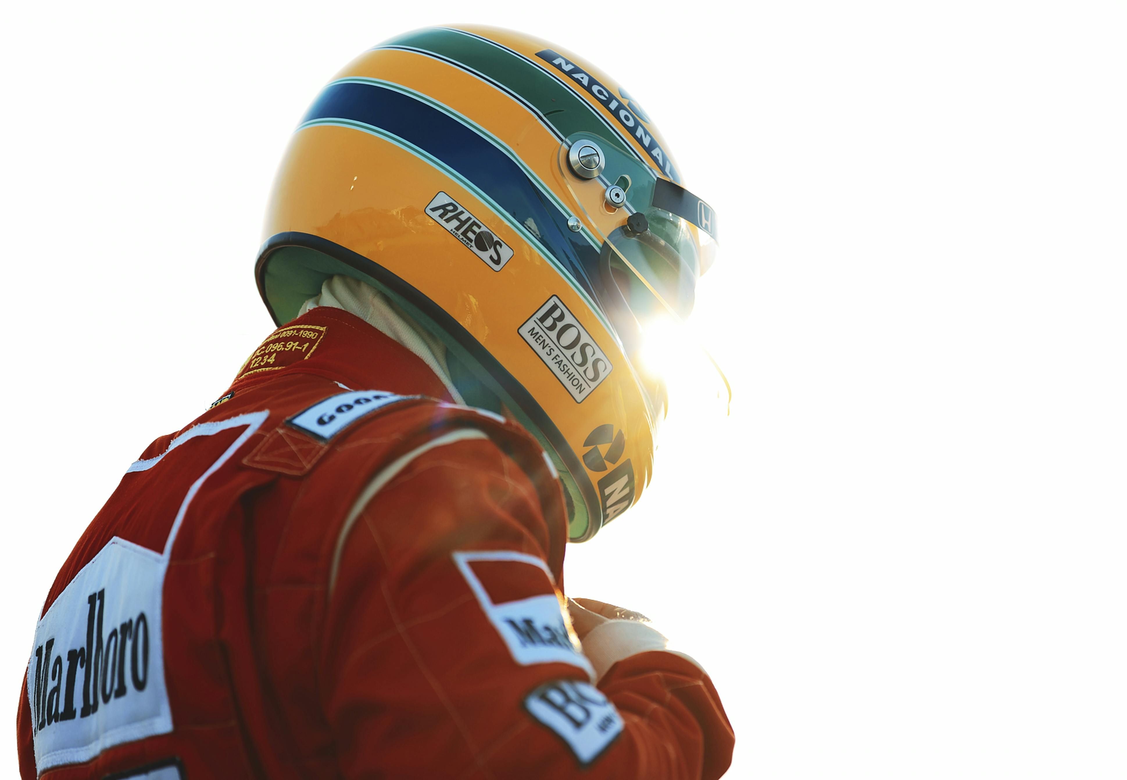 Ayrton Senna (Gabriel Leone) wears a red Marlboro jacket and a green-and-yellow helmet as he gears up to race.