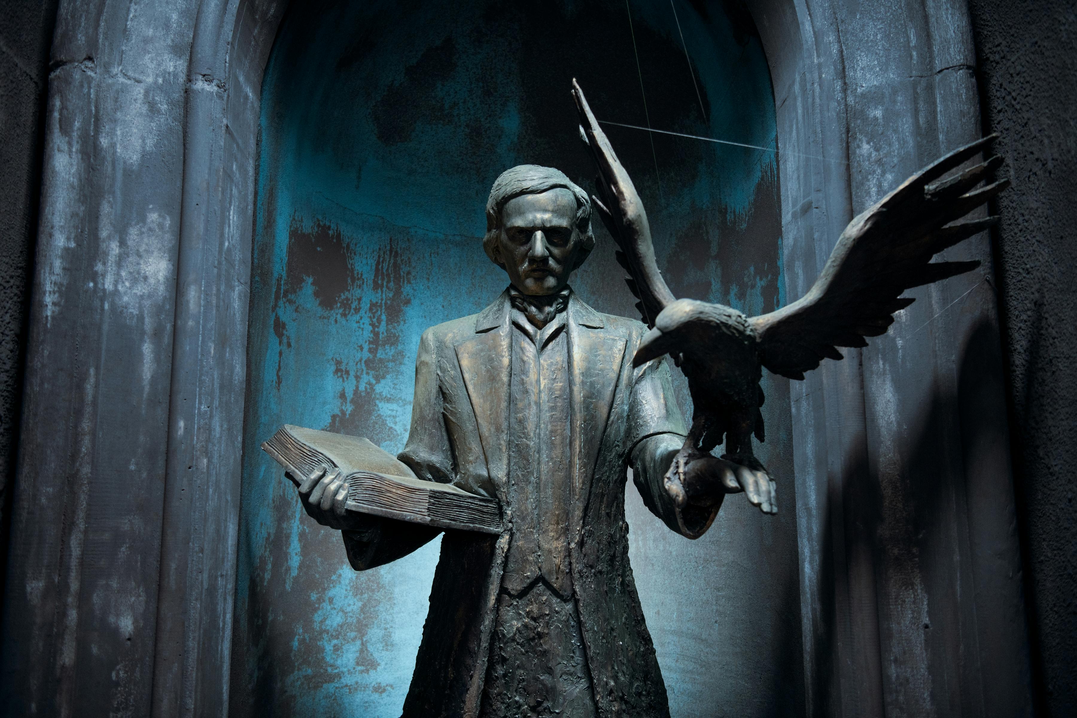 A statue at Nevermore — presumably of Edgar Allen Poe, because of the raven on his arm — holds a book and looks ominous. 