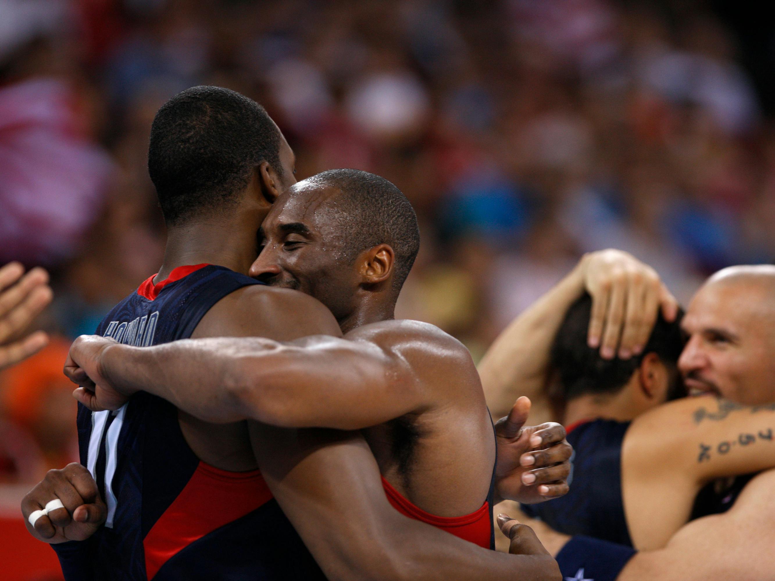 Dwight Howard and Kobe Bryant hug, and Jason Kidd hugs someone else in the background.