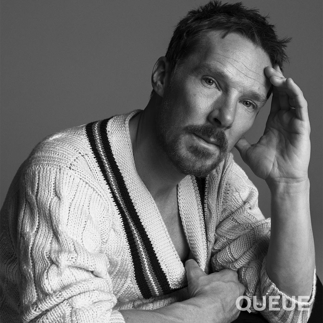 Benedict Cumberbatch wears a white cable-knit sweater in this black-and-white shot.