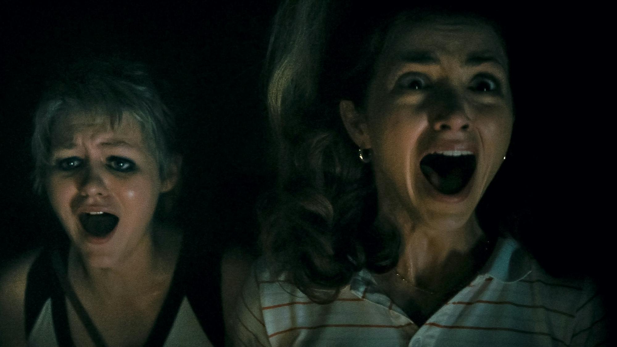 Alice (Ryan Simpkins) and Cindy (Emily Rudd) in a dark shot, with wide open mouths screaming.