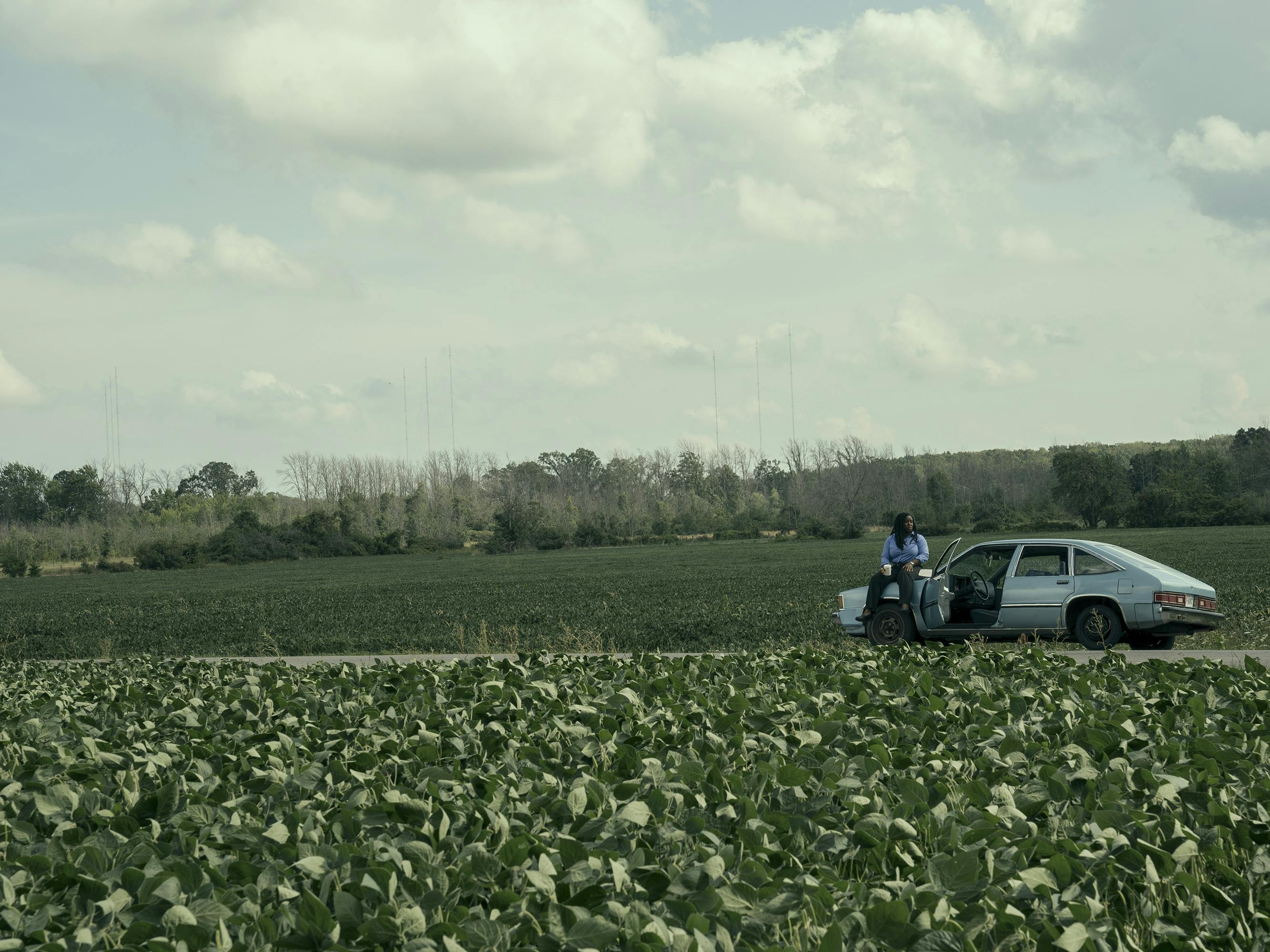 Edie Flowers (Uzo Aduba) sits on her car hood on the side of a country road.