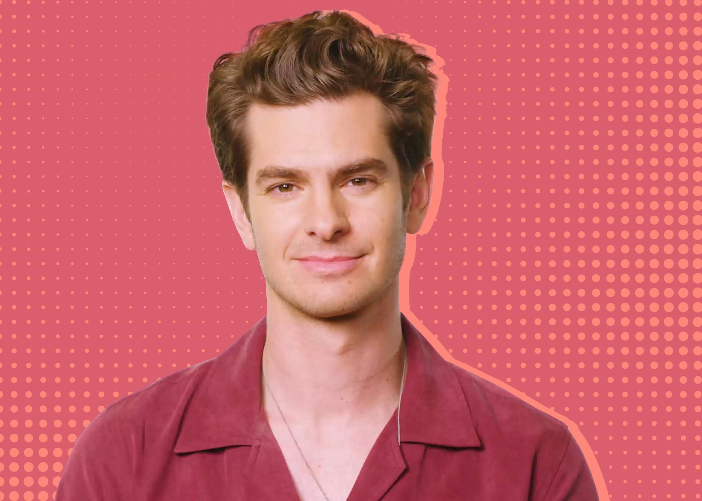 Andrew Garfield wears a red shirt and silver necklace. Behind him is a pink and red dotted treated background.