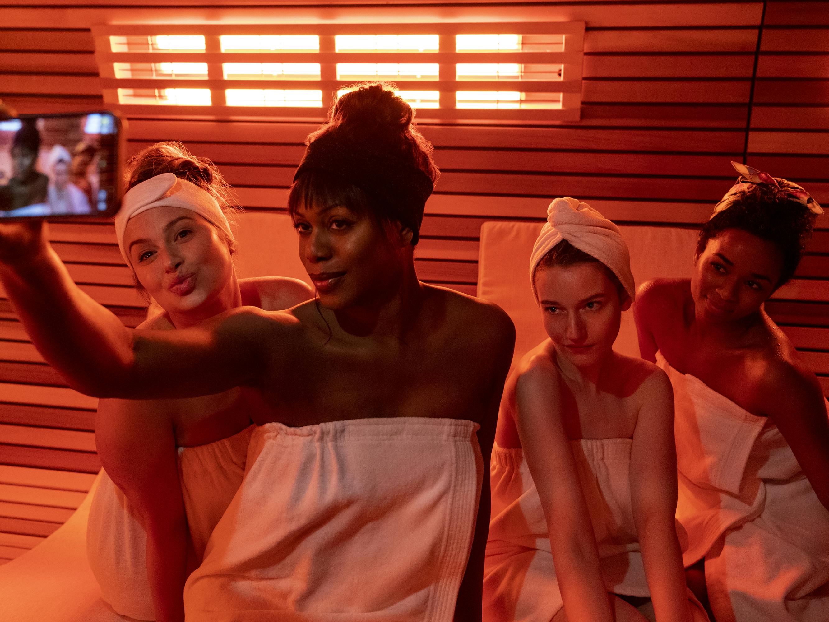 Katie Lowes, Laverne Cox, Julia Garner, and Alexis Floyd take a selfie in an orange-lit saua