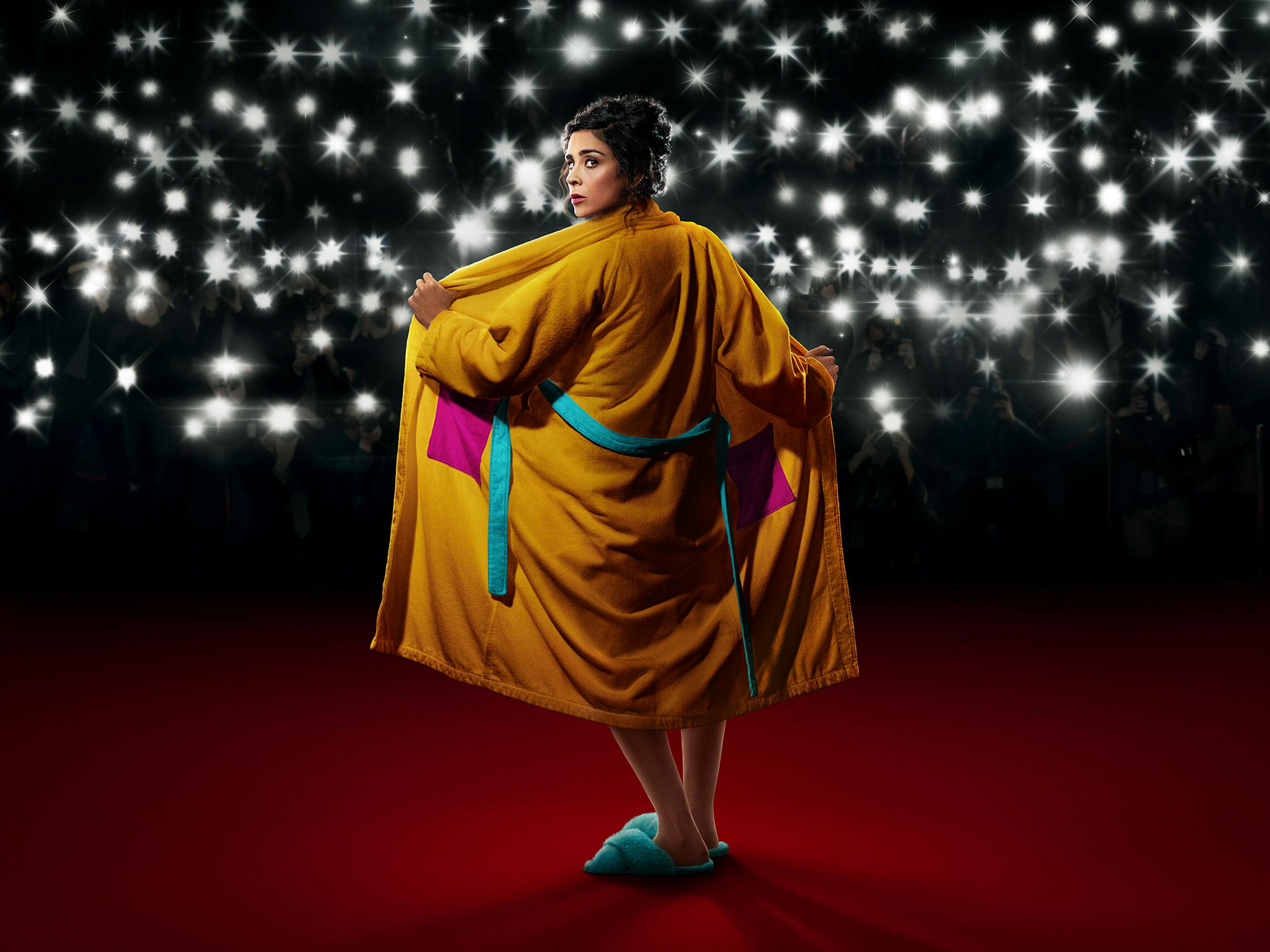 Sarah Silverman wears a yellow robe and opens it up to a crowd of paparazzi. 