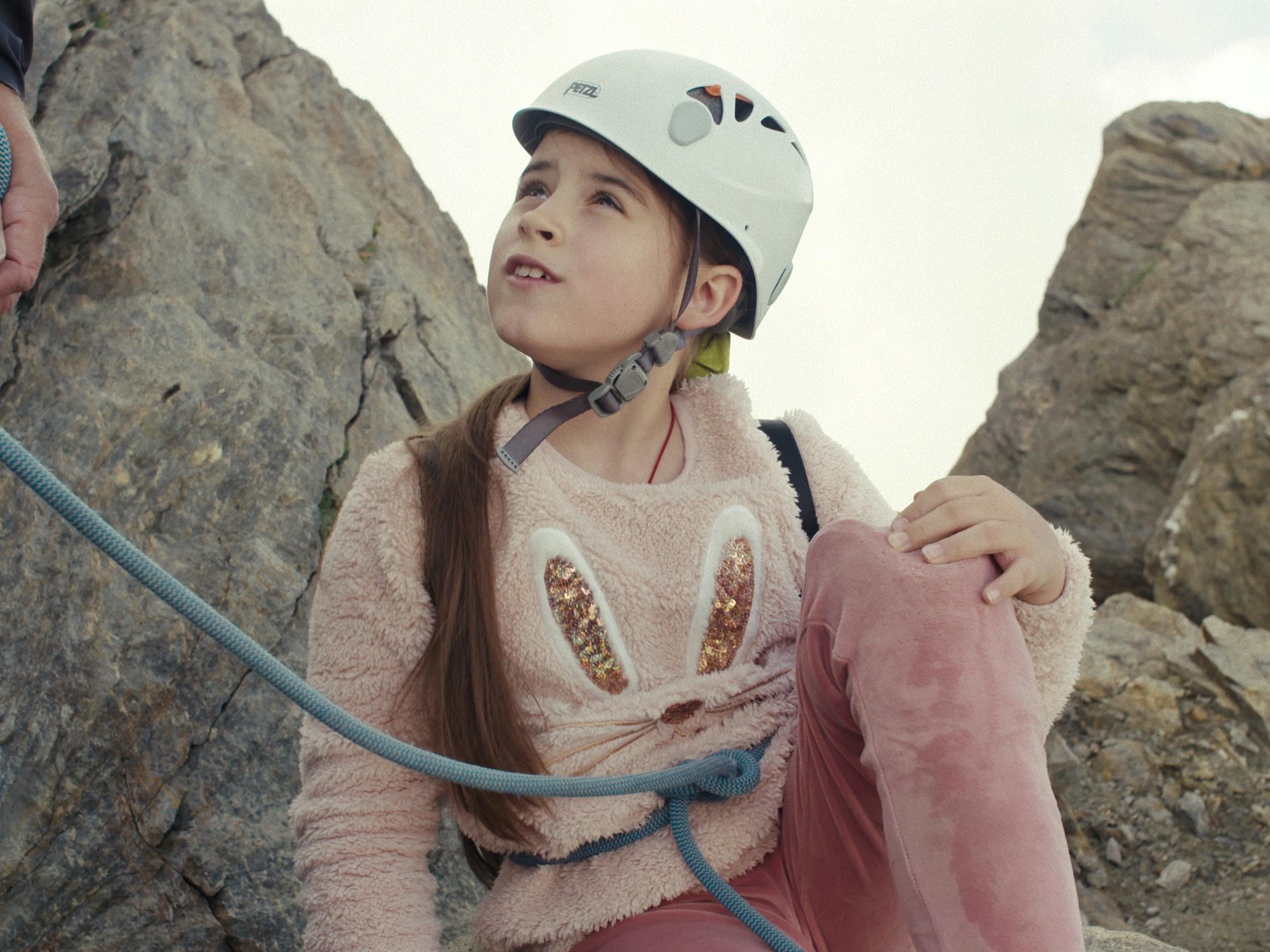 Milana wears a pink ensemble at the top of a mountain. 