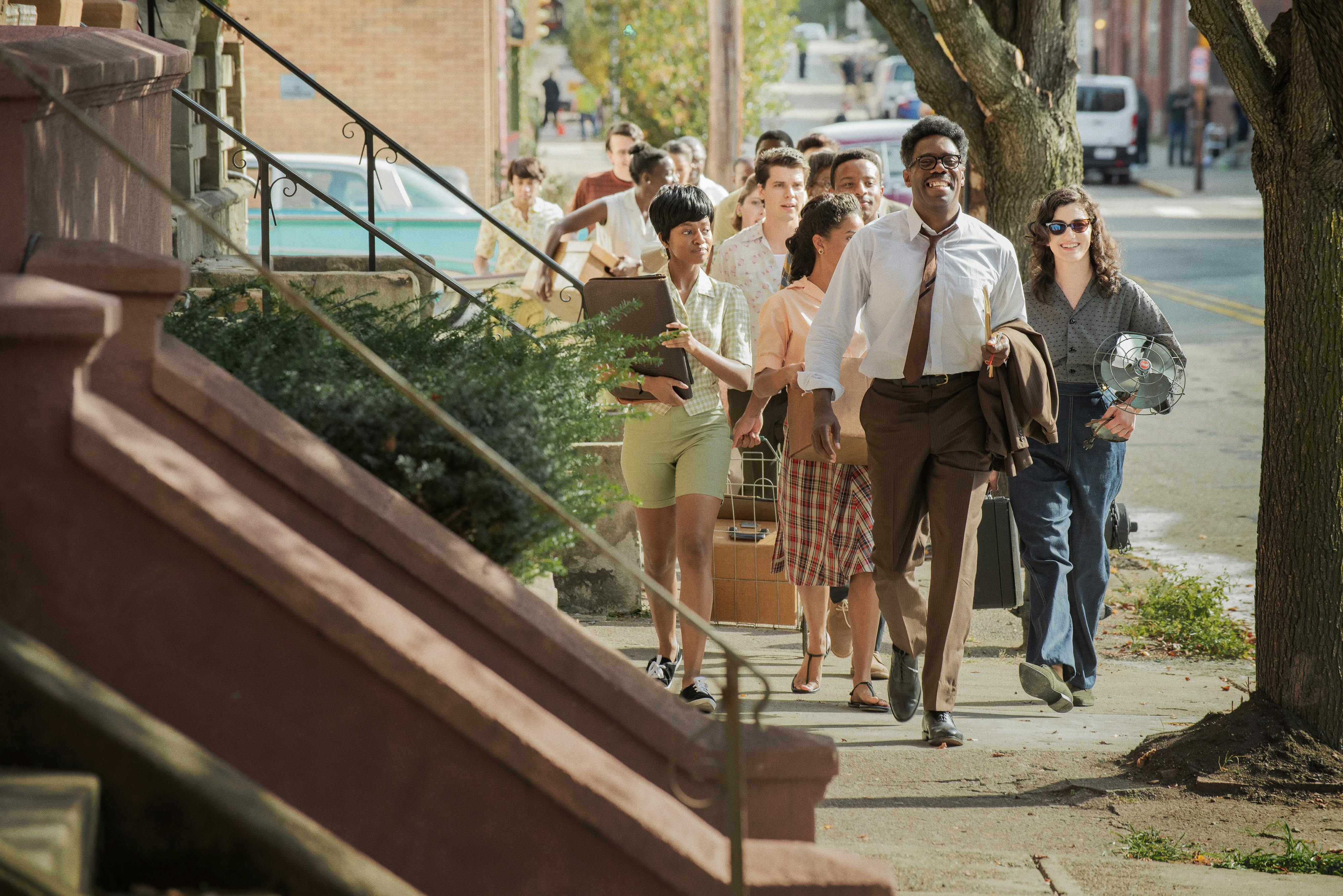 Bayard Rustin (Colman Domingo) marches along a city sidewalk with a crowd of people following him.