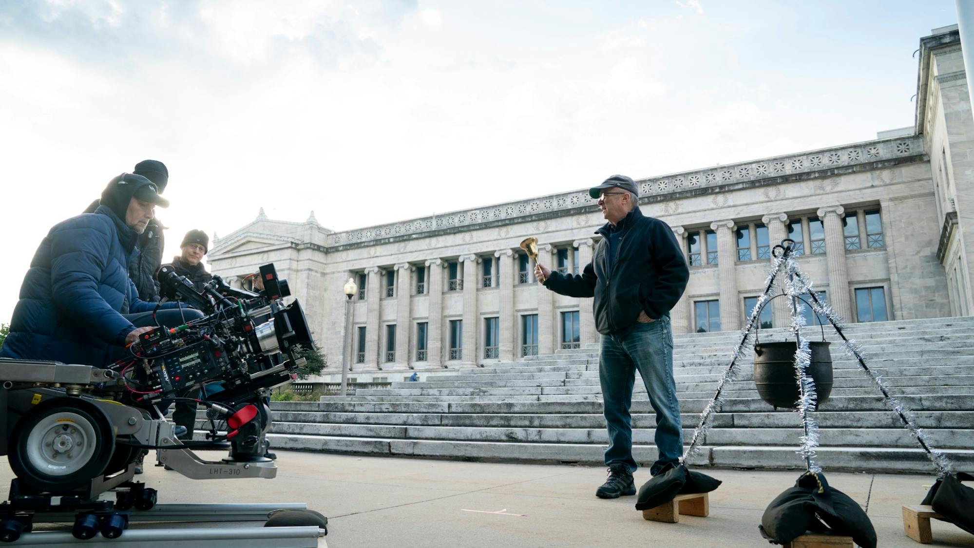 Papamichael sits on a camera rig, framing an outdoor shot of the Chicago Field Museum on a sunny day. 