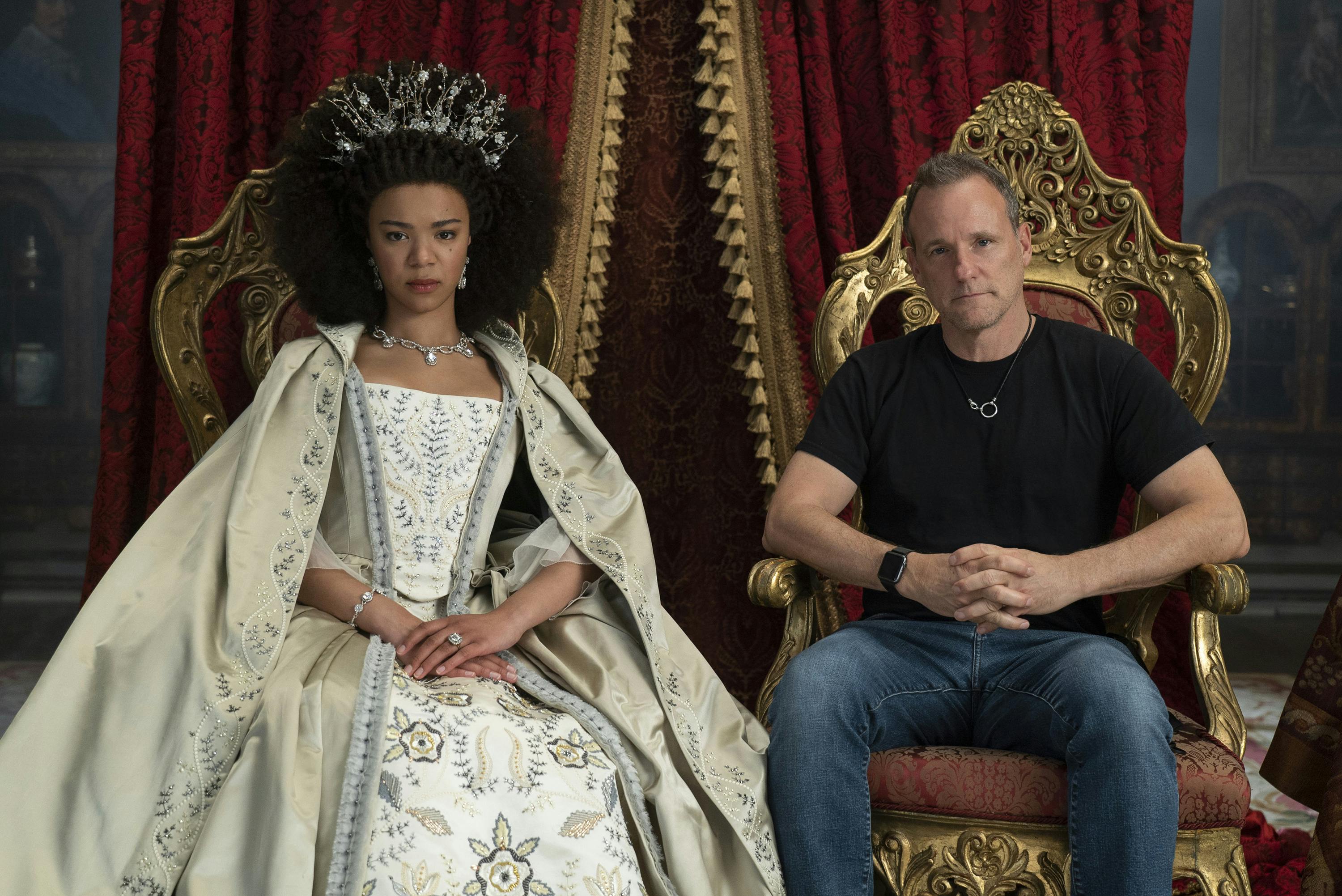 India Amarteifio and Tom Verica sit in thrones with very serious expressions. 