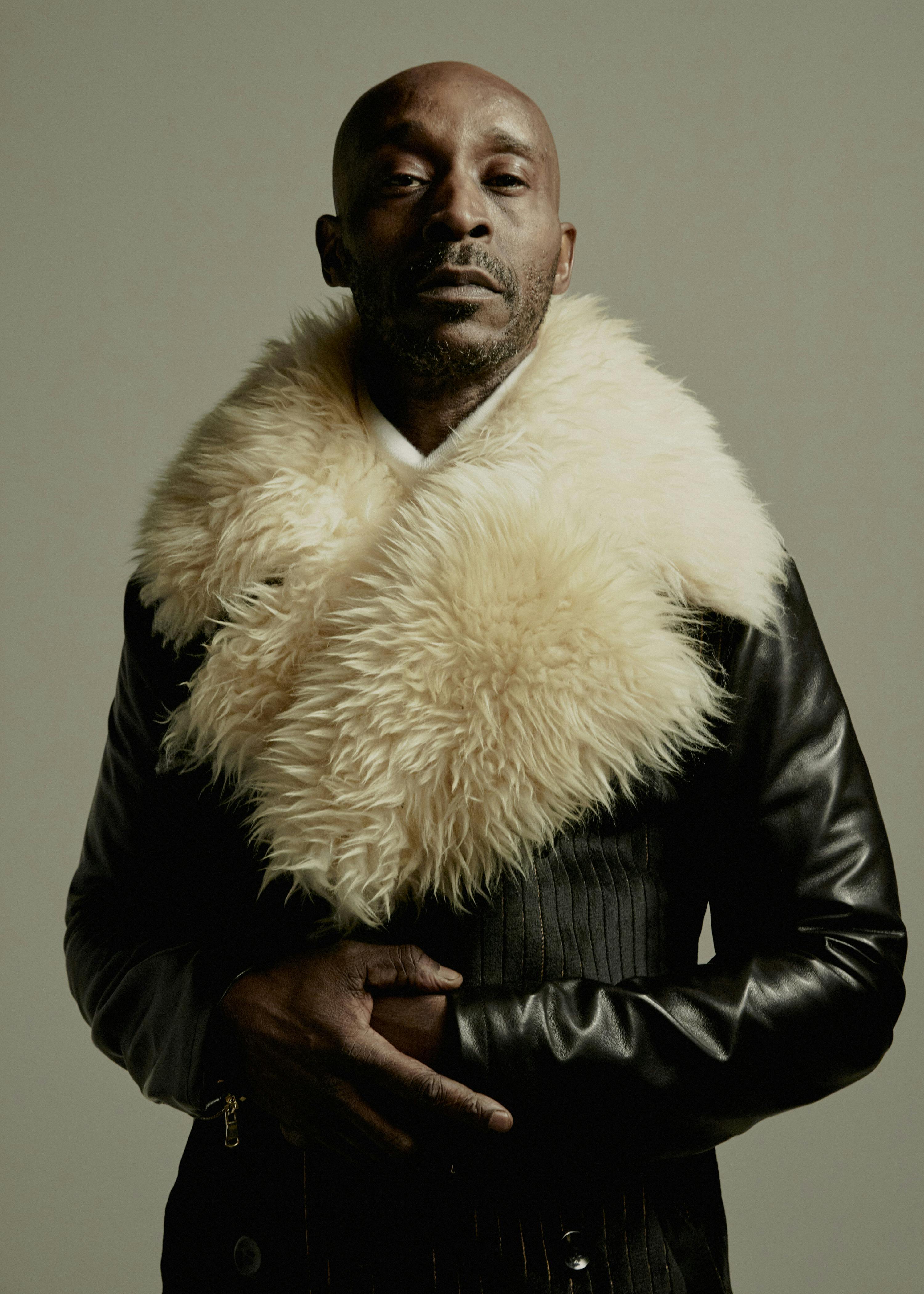 Rob Morgan wears a leather jacket with a massive furry collar.