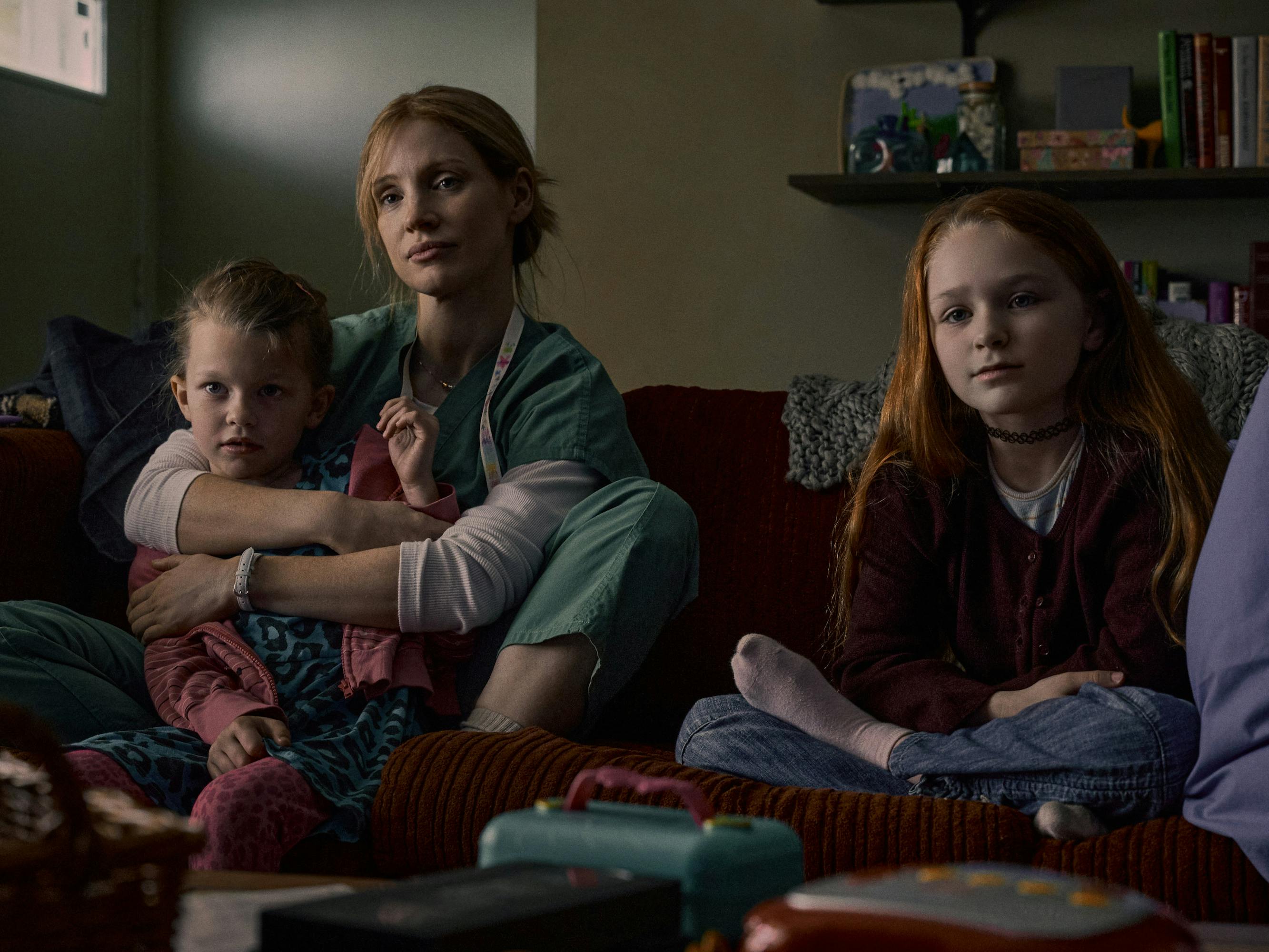 Maya Loughren (Devyn McDowell), Amy Loughren (Jessica Chastain), and Alex Loughren (Alix West Lefler) sit on a couch together.