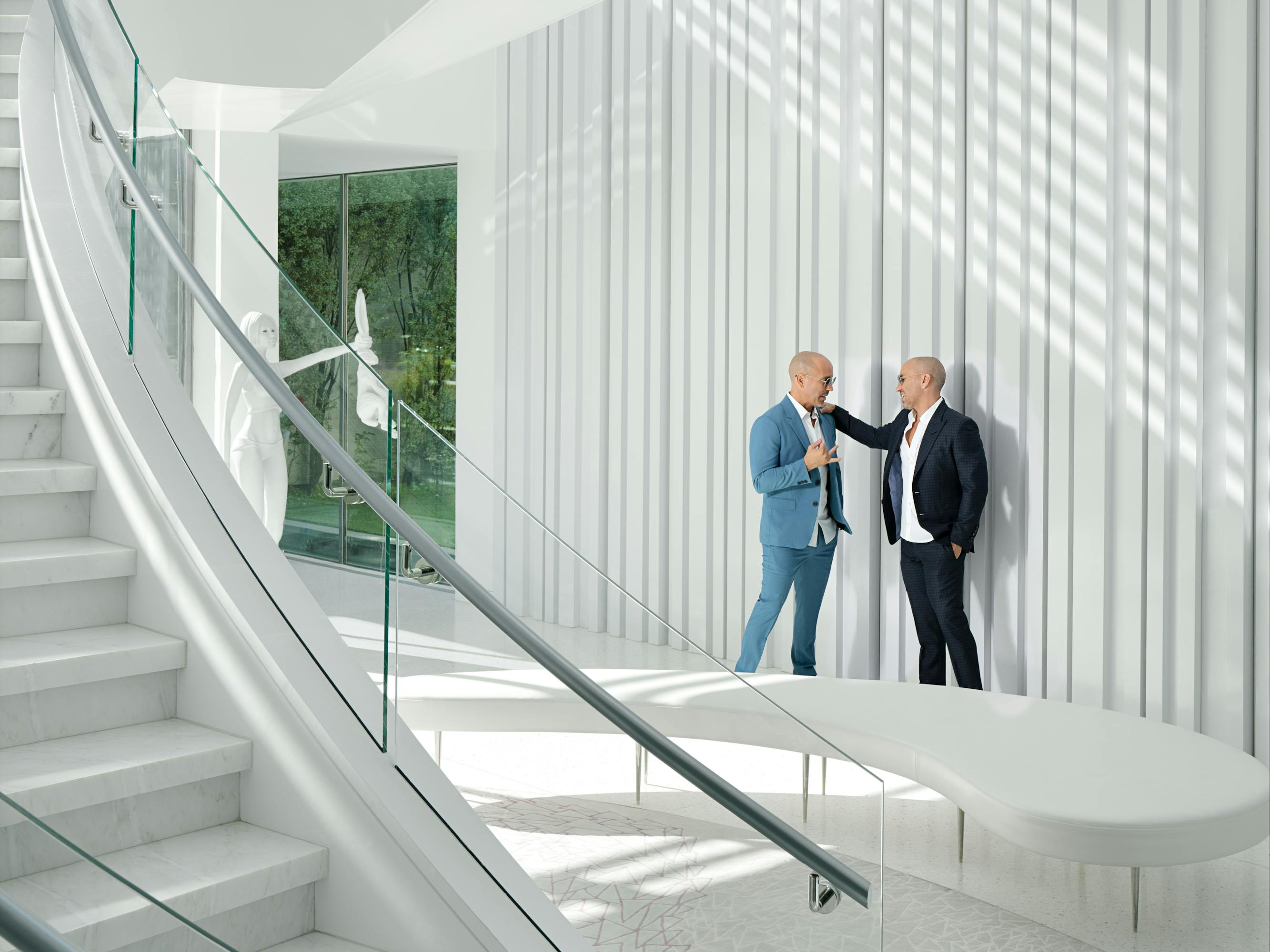 Brett and Jason Oppenheim stand together in a sunlit white room. 