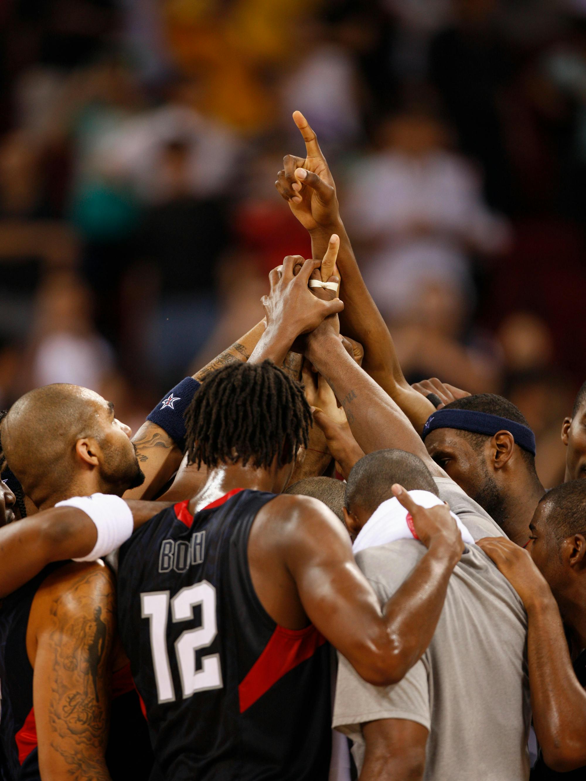 The Redeem Team celebrate in a huddle.