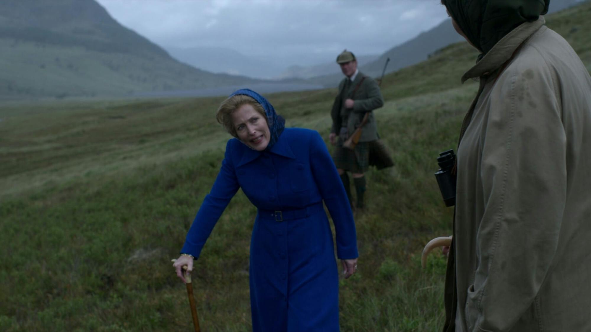 Margaret Thatcher wears a striking blue outfit that stands out amidst the greens and greys of Balmoral. Her dissonant outfit matches her uncomfortable expression.