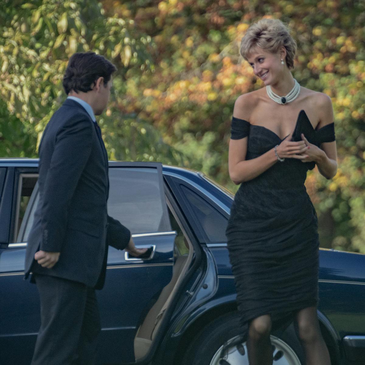 Princess Diana (Elizabeth Debicki) wears the epic revenge dress, diamond choker, and sheer tights as she steps out of a station wagon.