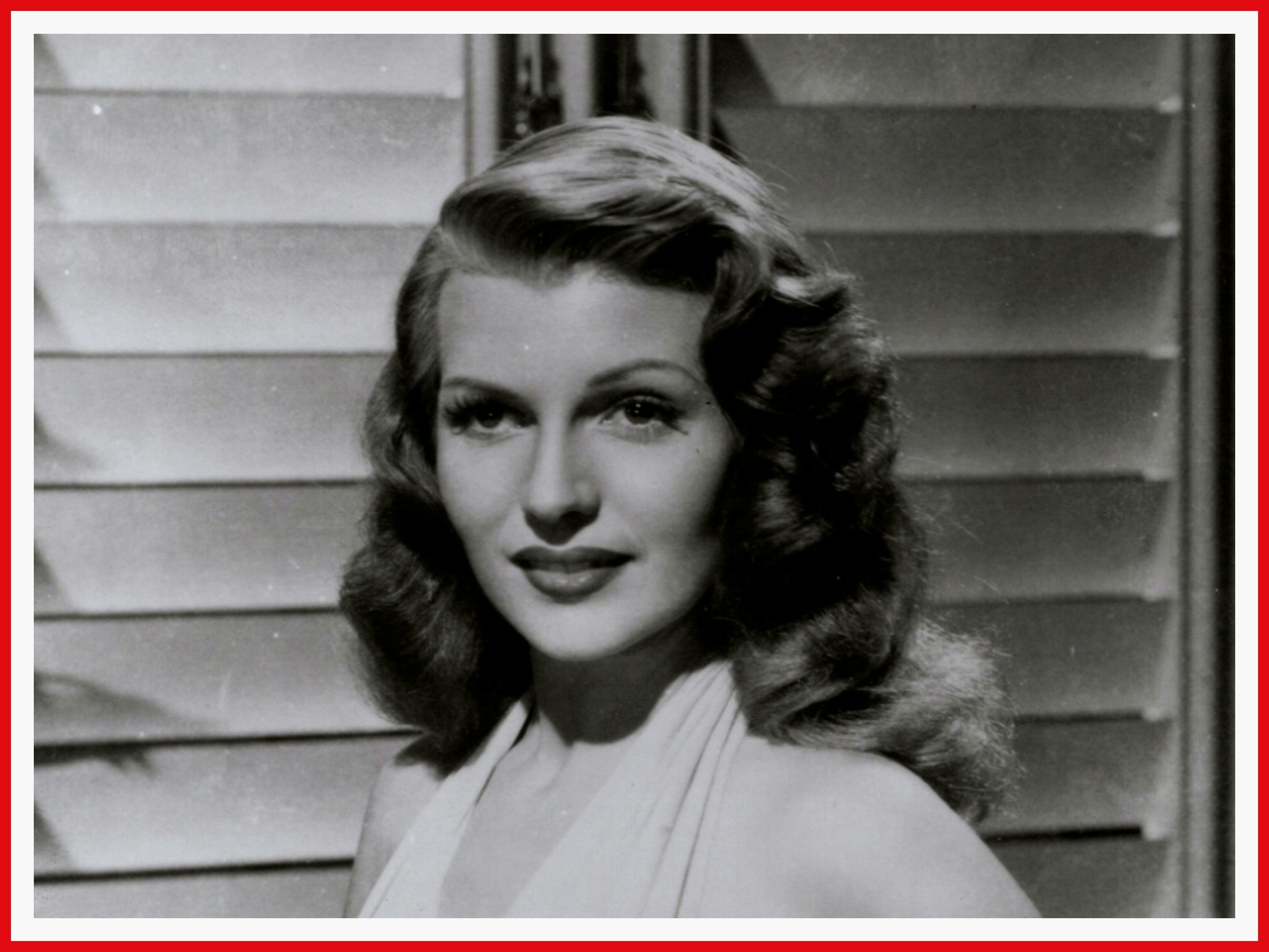 Hayworth as the title character, looking glamorous with tressed hair in a white halter dress