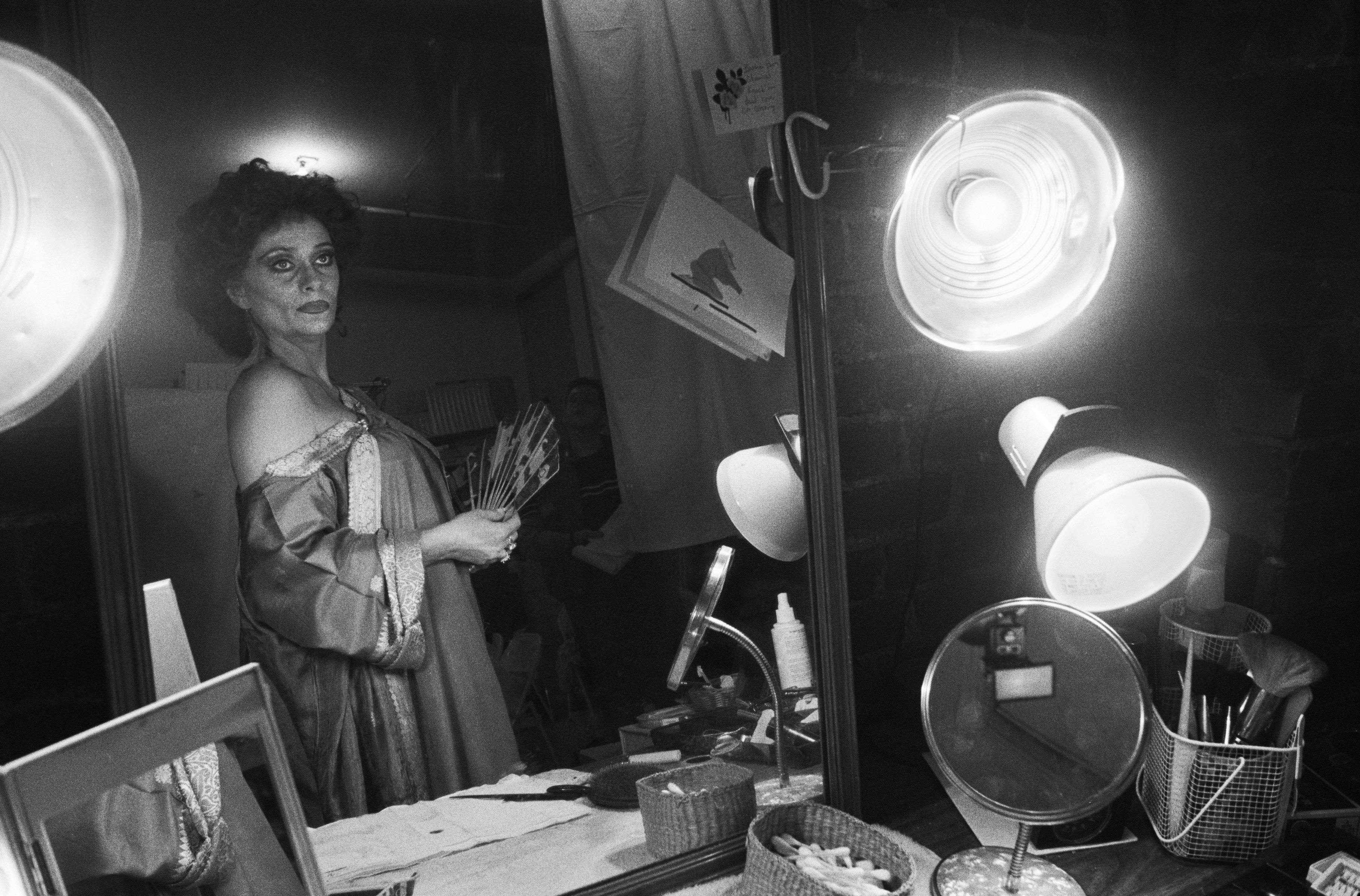 Elizabeth Ashley looks at herself in a mirror in this black-and-white shot.