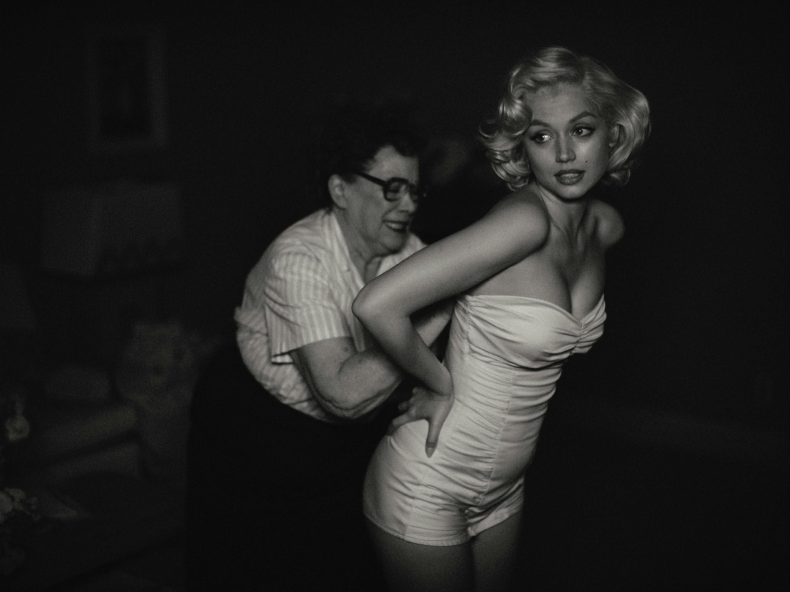 Marilyn Monroe (Ana de Armas) gets unzipped out of a white corset top.