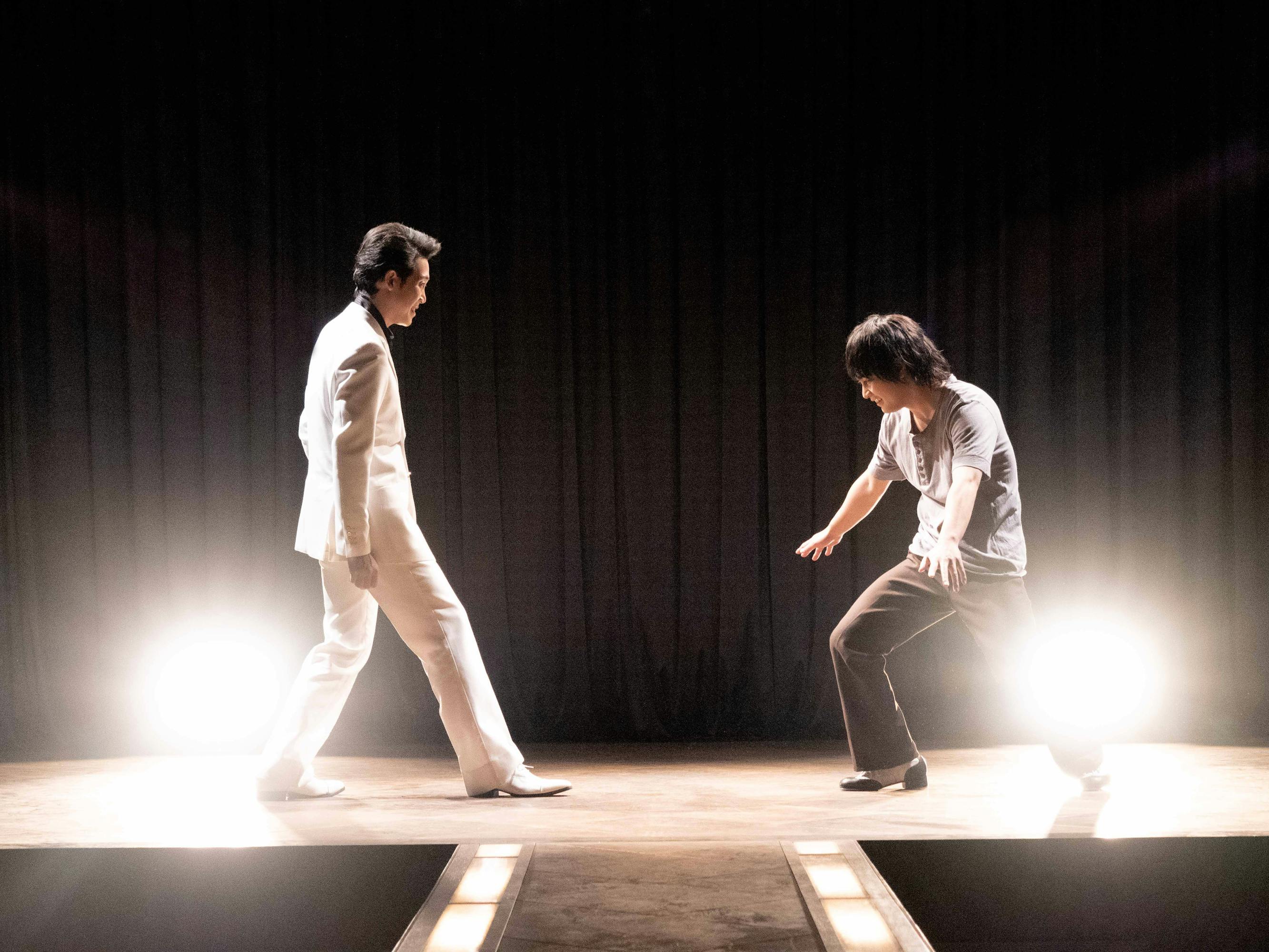 Yo Oizumi and Yuya Yagira stand along a brightly lit stage.