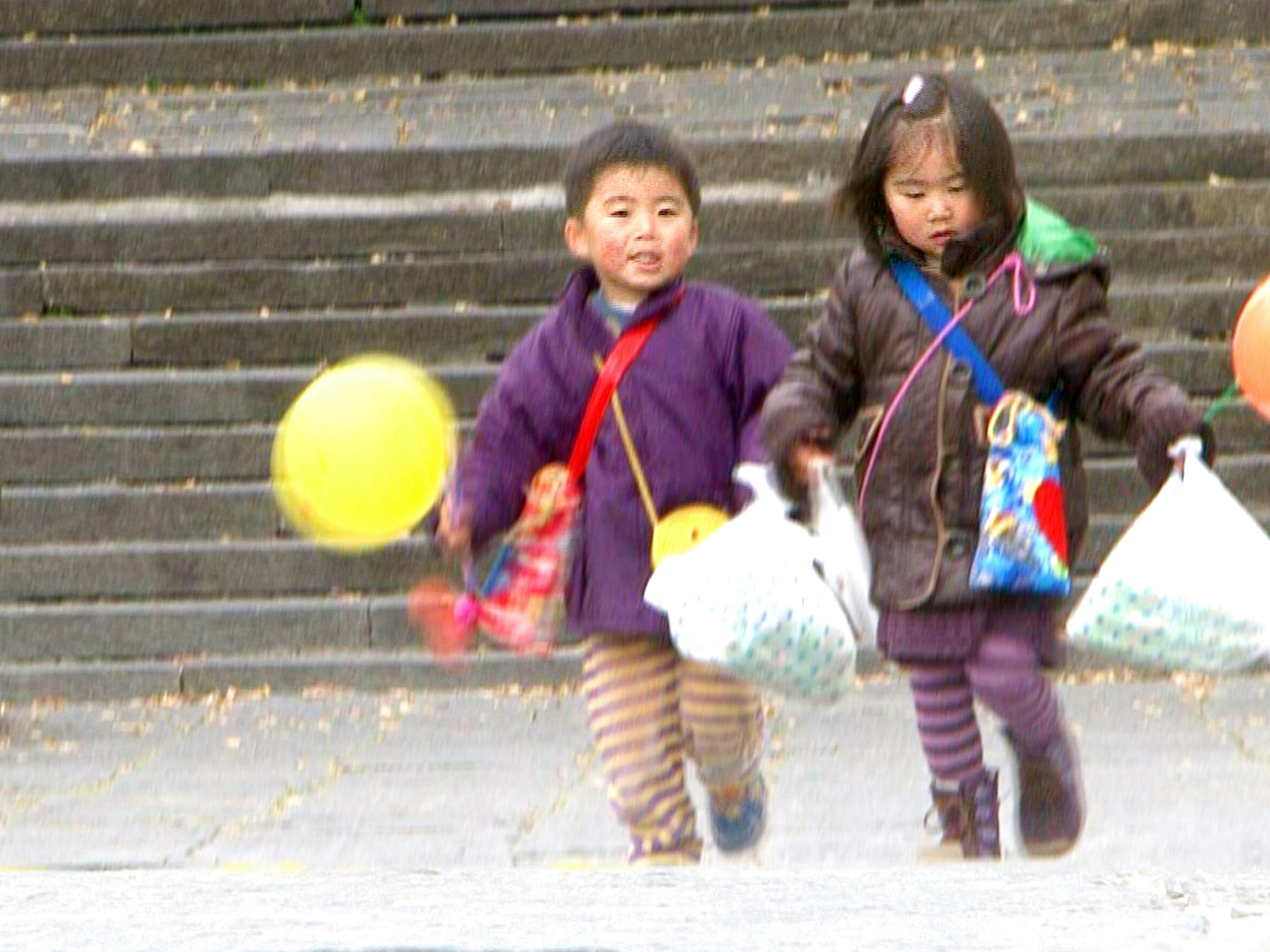 Naoki and Seina in Old Enough! hold plastic bags and carry balloons. They both wear striped pants.