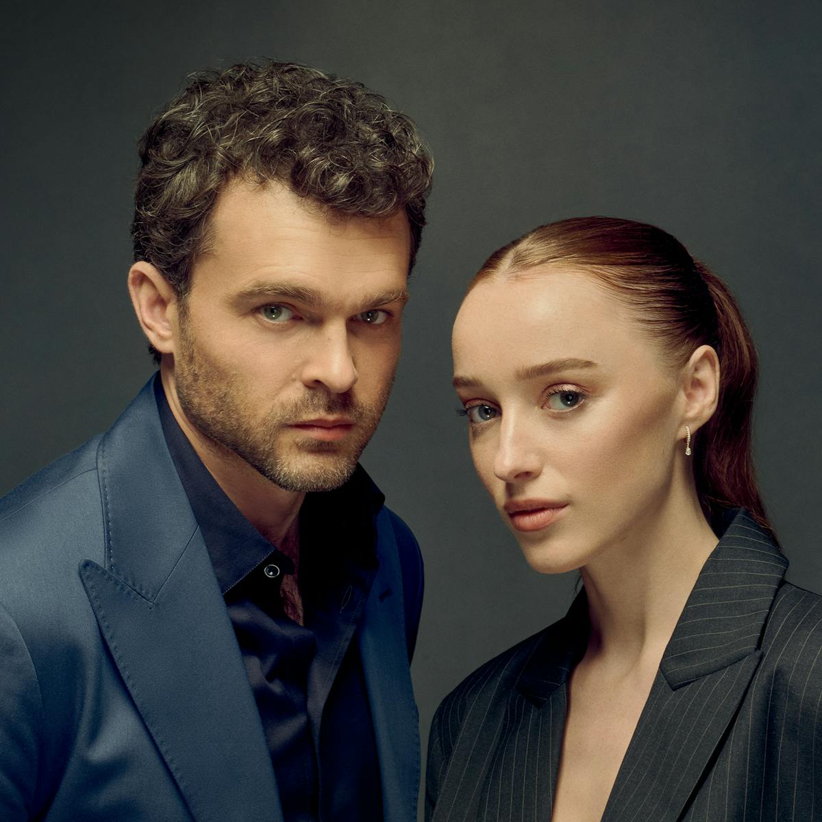 Alden Ehrenreich and Phoebe Dynevor pose in navy and black blazers, respectively, looking snatched and serious.